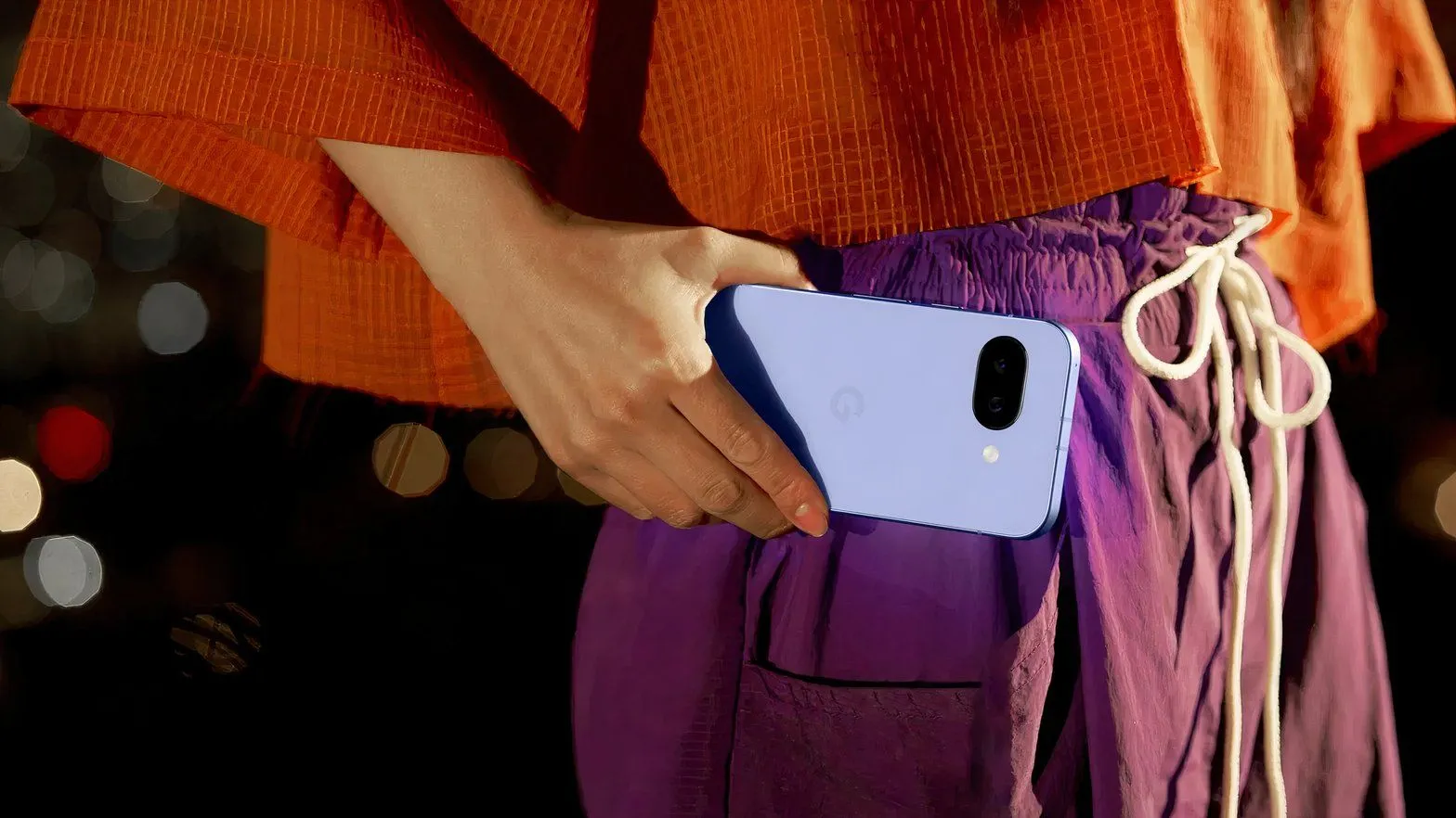 Ảnh cận cảnh người phụ nữ cầm điện thoại Google Pixel 9a, làm nổi bật thiết kế và sự tiện lợi khi sử dụng hàng ngày.