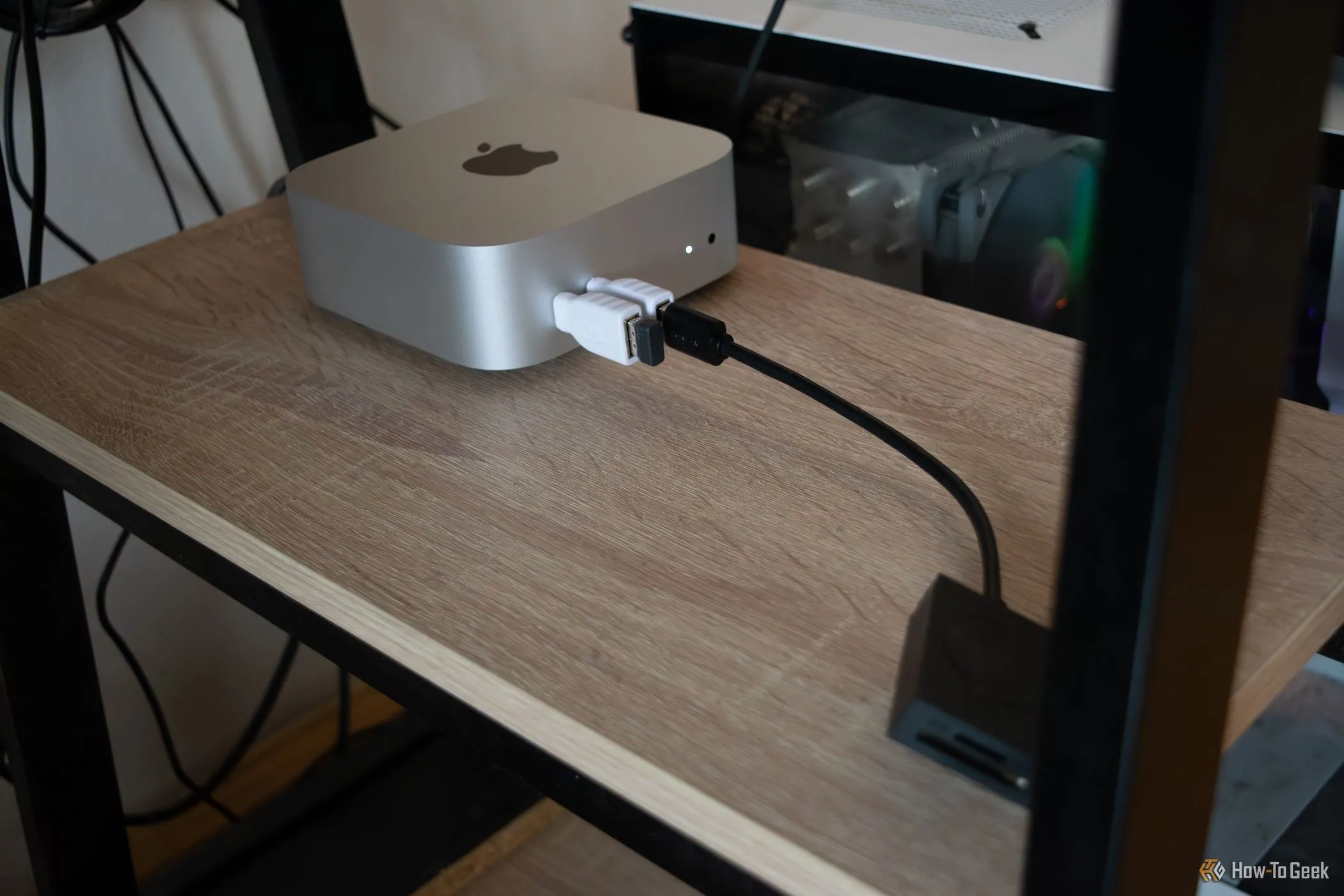 Apple Mac Mini M4 được đặt gọn gàng trên kệ dưới bàn làm việc, tối ưu không gian