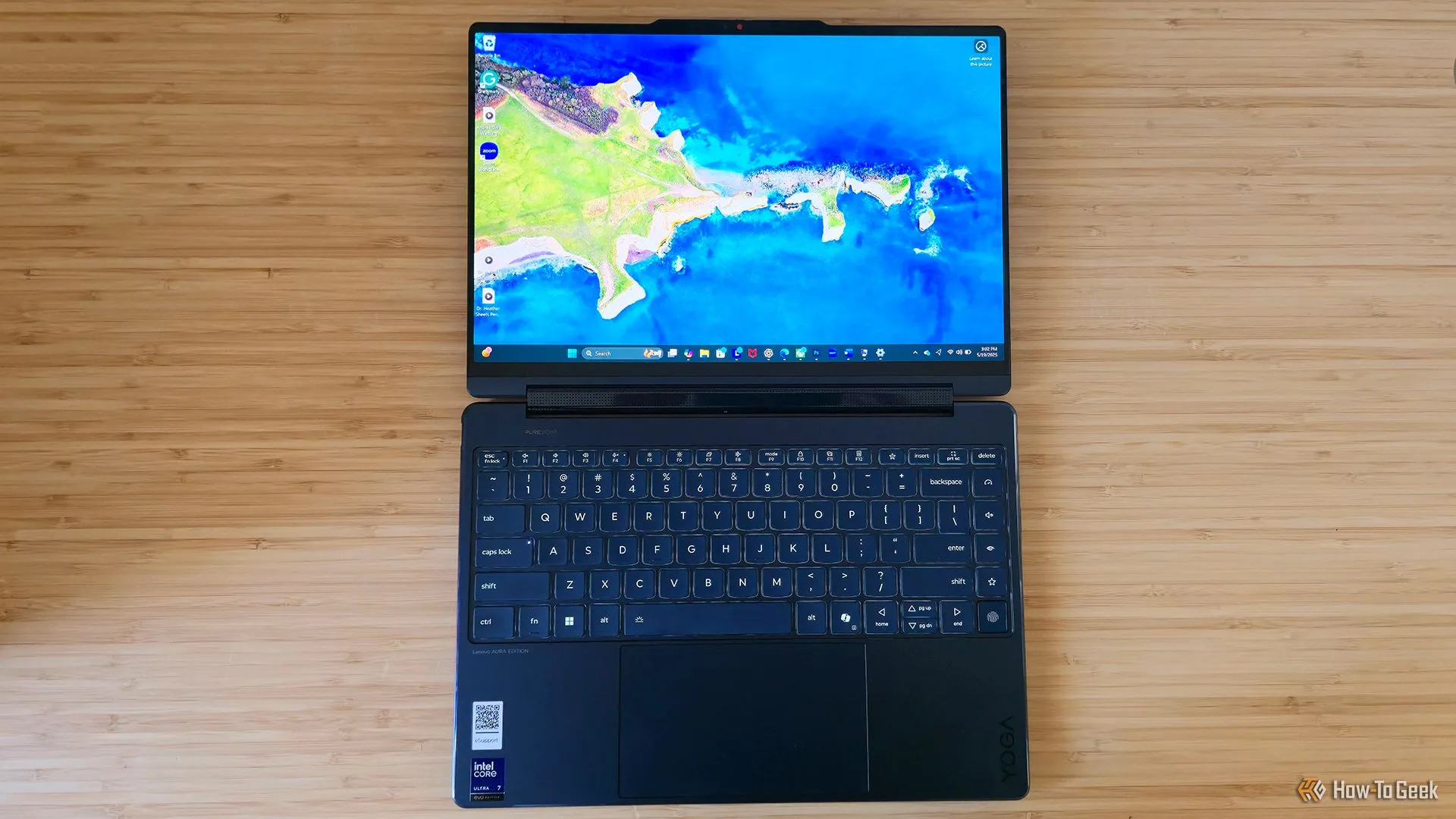 Laptop Lenovo Yoga 9i 2-in-1 Gen 10 nằm phẳng trên bàn làm việc.