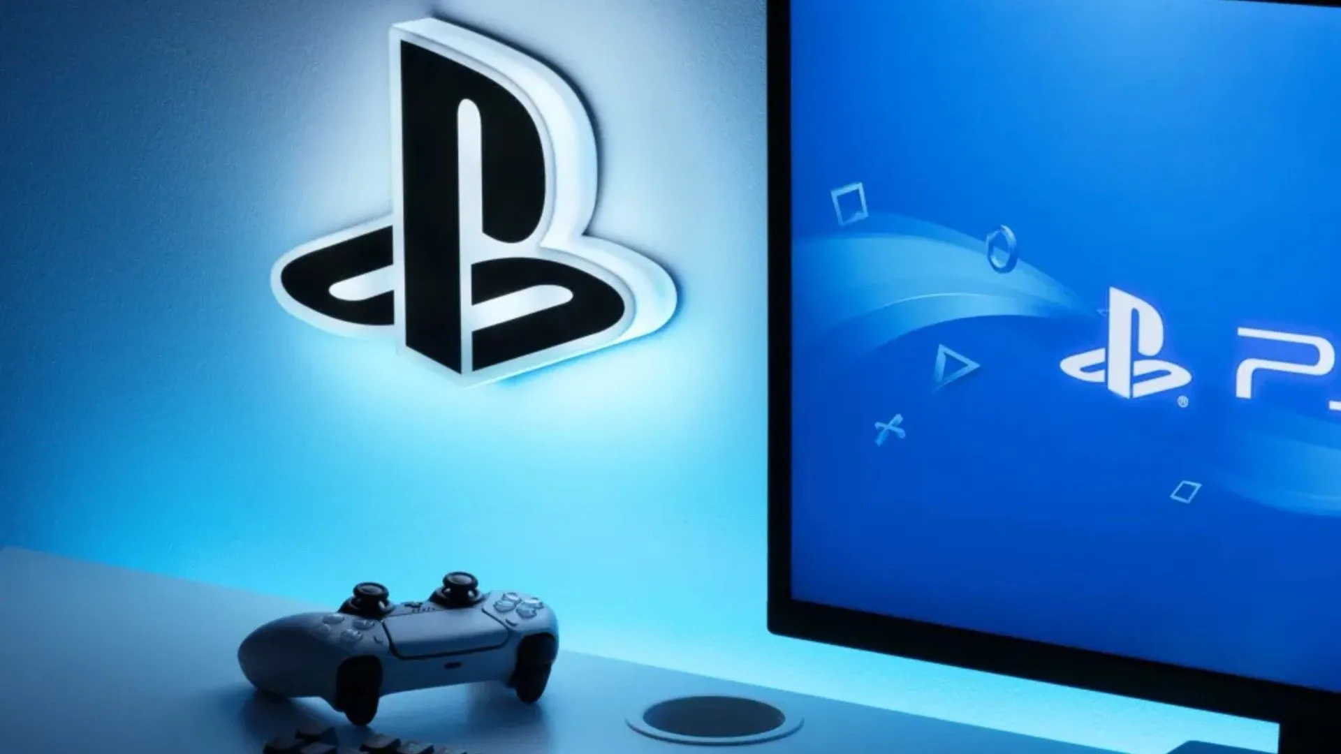 Logo PlayStation trên tường cùng tay cầm DualSense và màn hình hiển thị logo PS5, tượng trưng cho trải nghiệm game trên PS5 Pro