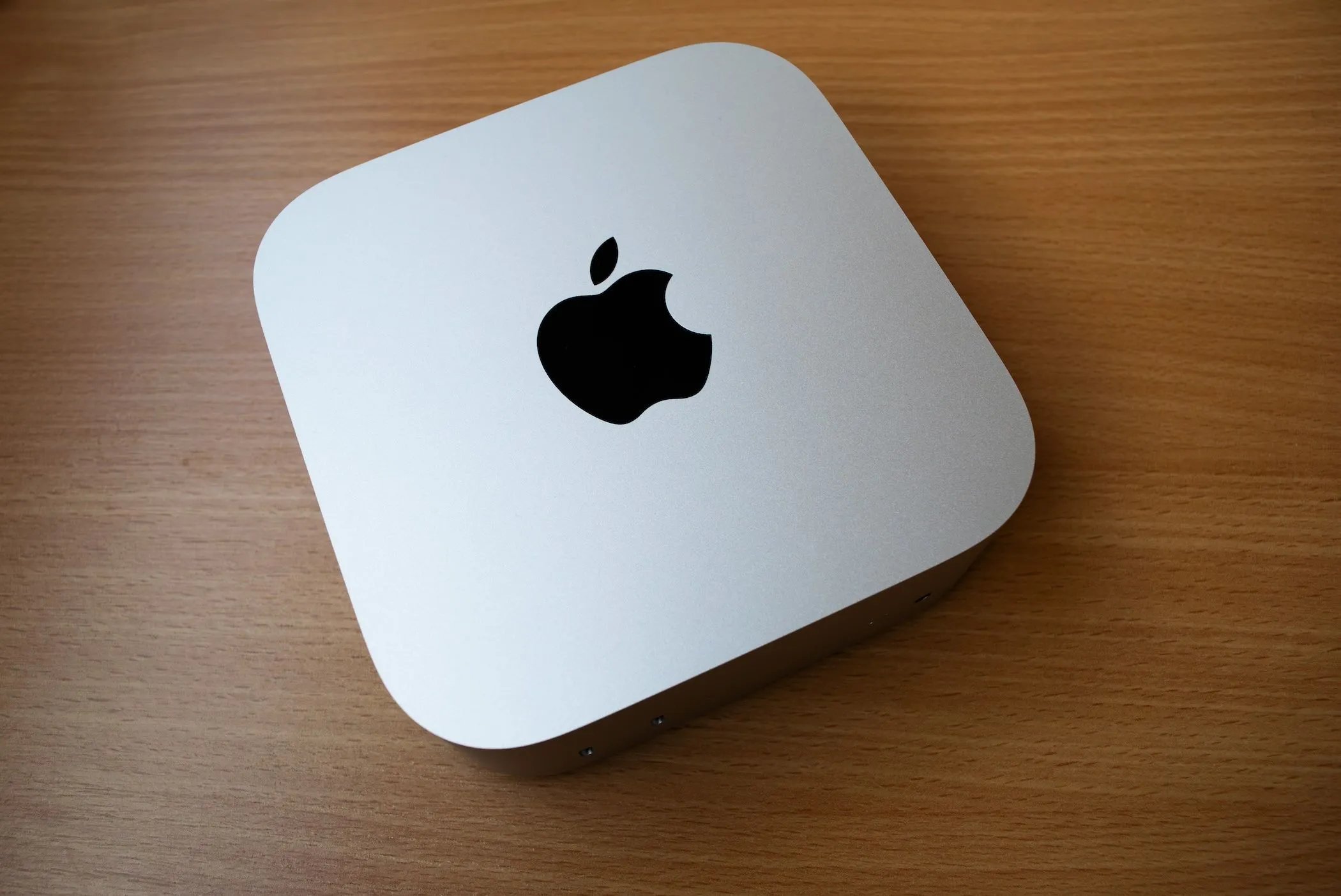 Mac Mini M4 nhỏ gọn đặt trên bàn gỗ, thể hiện tính linh hoạt trong sắp xếp