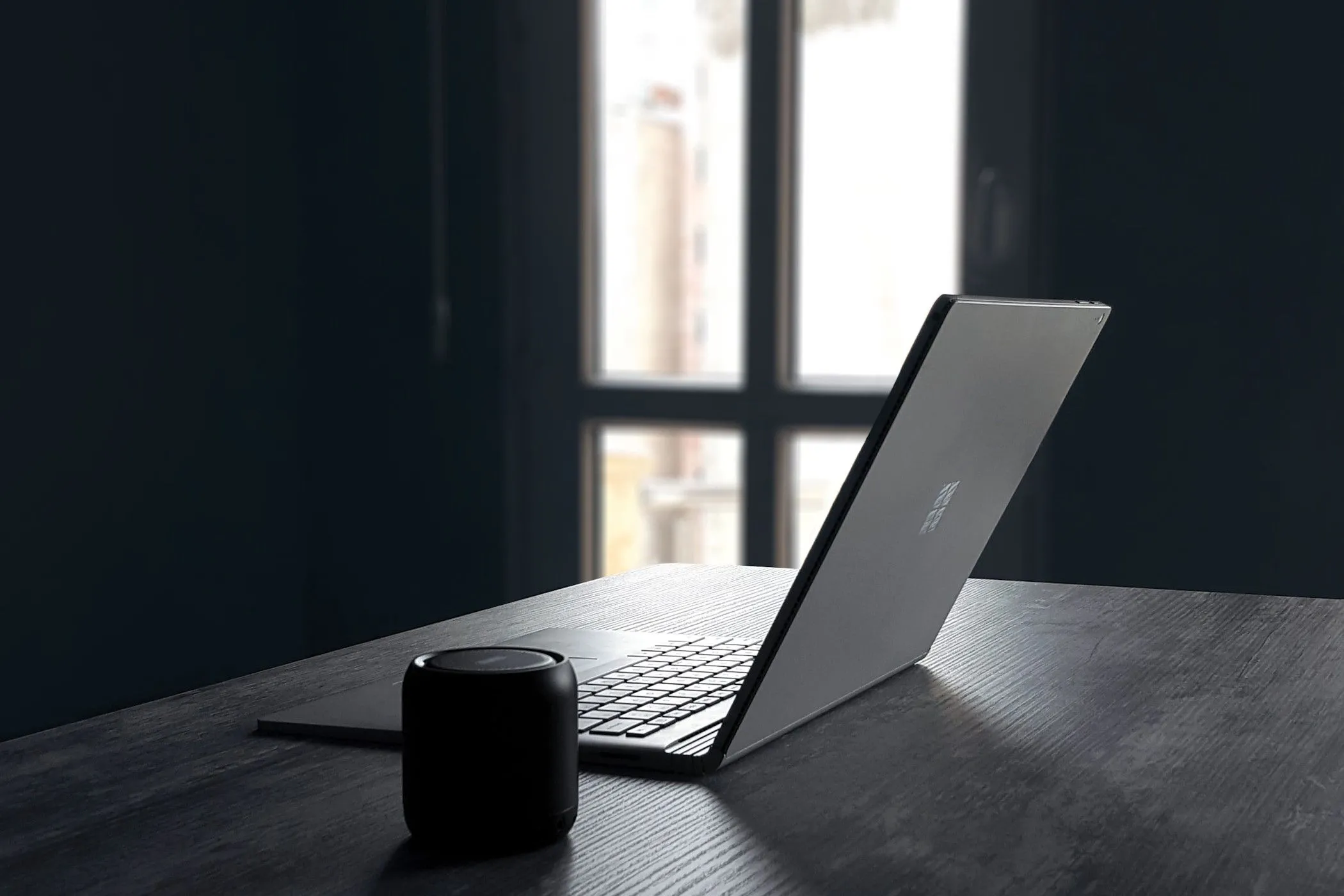 Máy tính xách tay Windows và loa Bluetooth, minh họa môi trường làm việc đa nền tảng.
