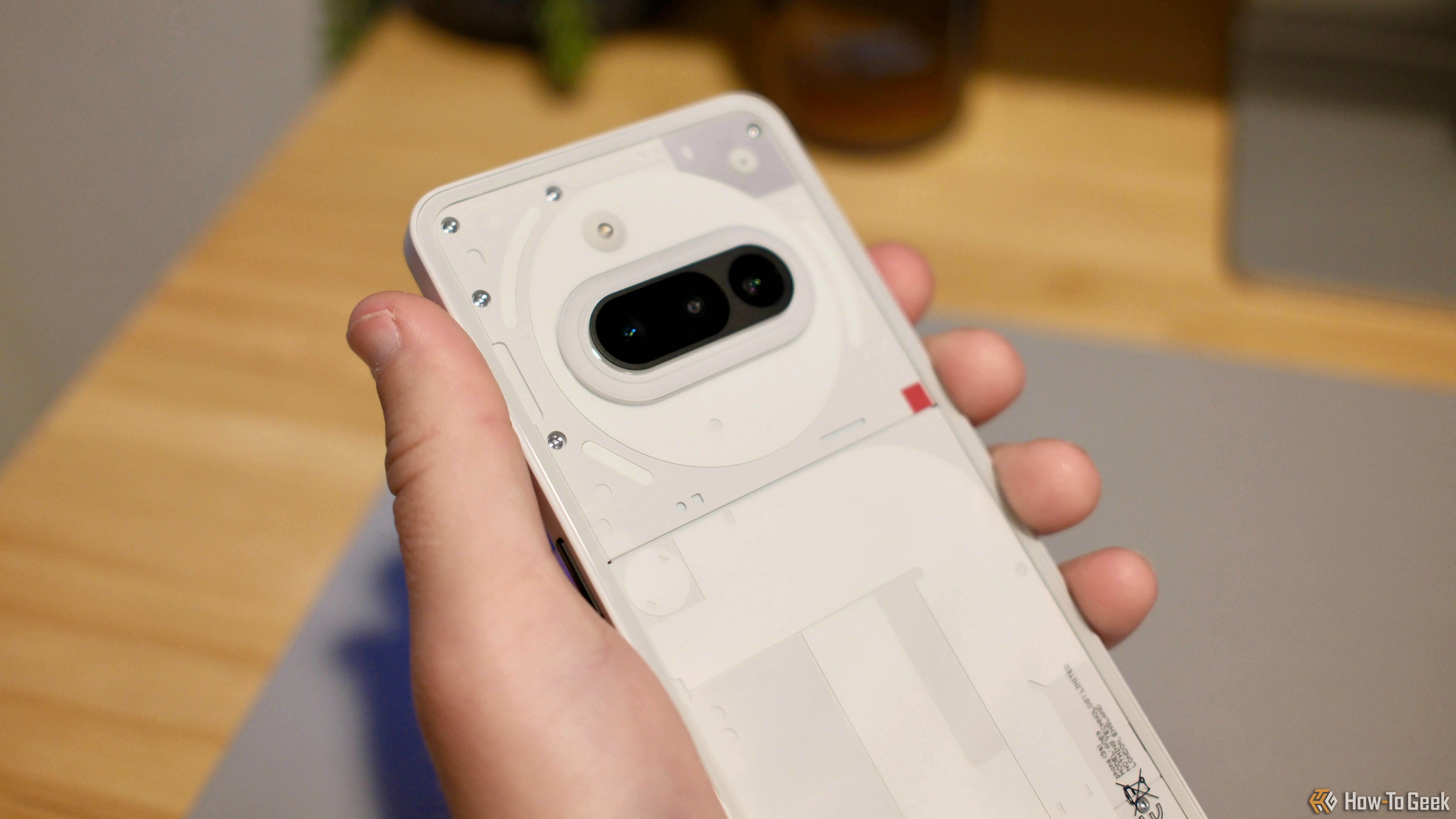 Một bàn tay đang cầm Nothing Phone (3a), thể hiện kích thước và trải nghiệm cầm nắm thực tế của thiết bị.