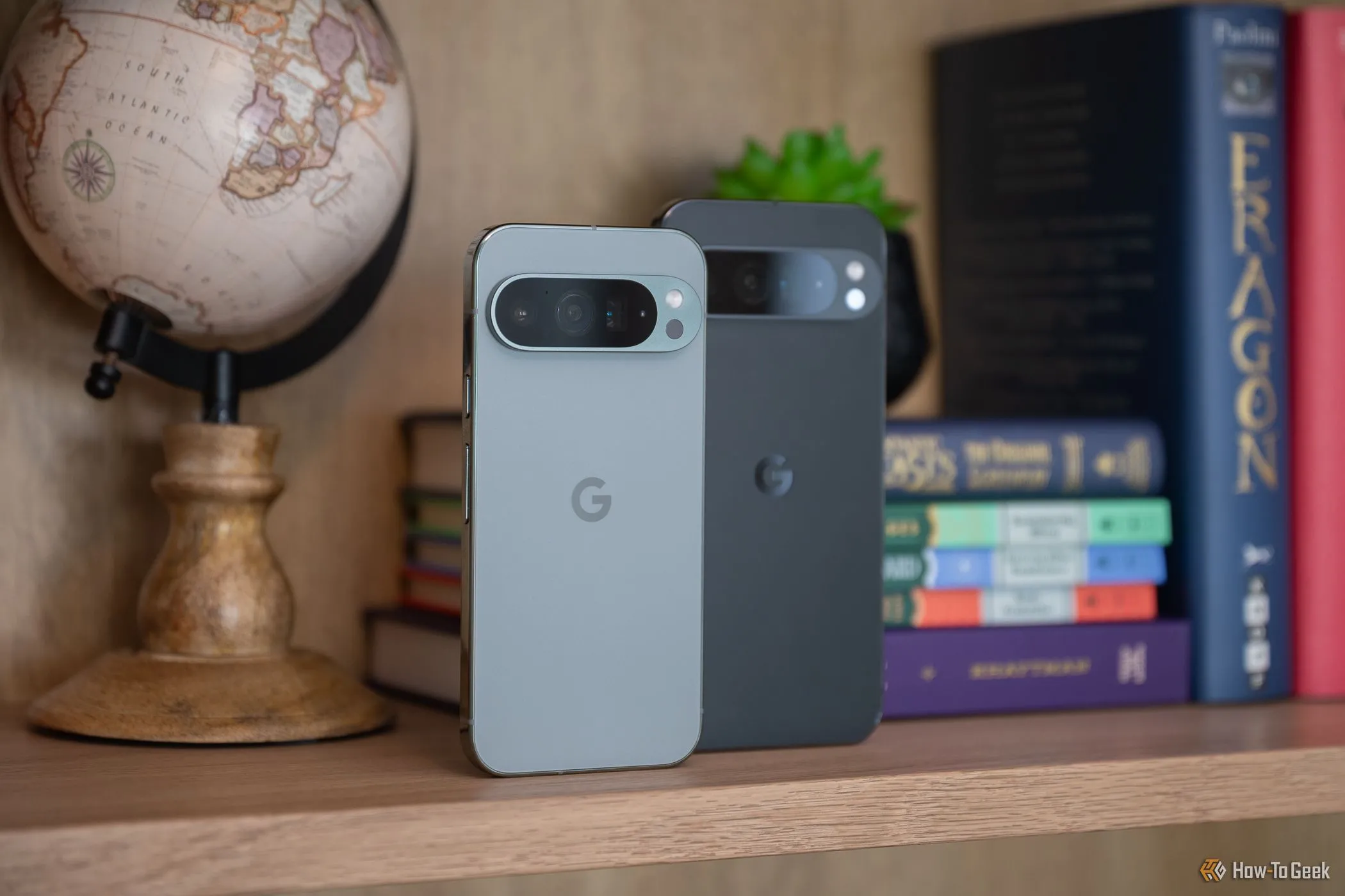 Một điện thoại Google Pixel 9 Pro và một Google Pixel 9 Pro XL đứng cạnh nhau trên kệ