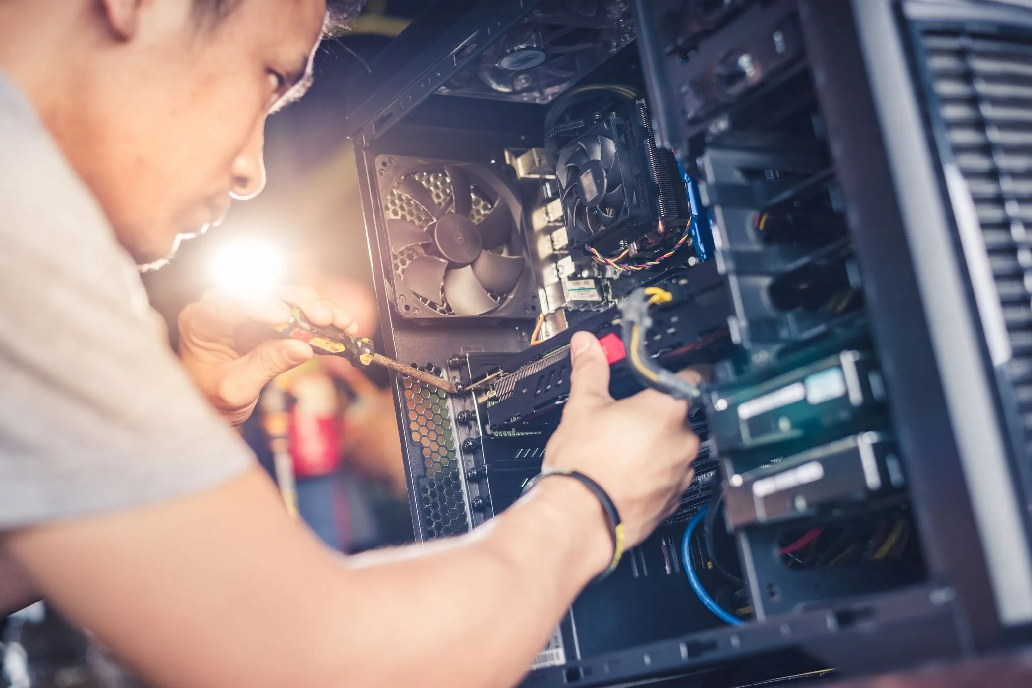 Một kỹ thuật viên đang lắp đặt card đồ họa vào máy tính, hình ảnh tượng trưng cho hoạt động hỗ trợ kỹ thuật liên quan đến PC gaming.