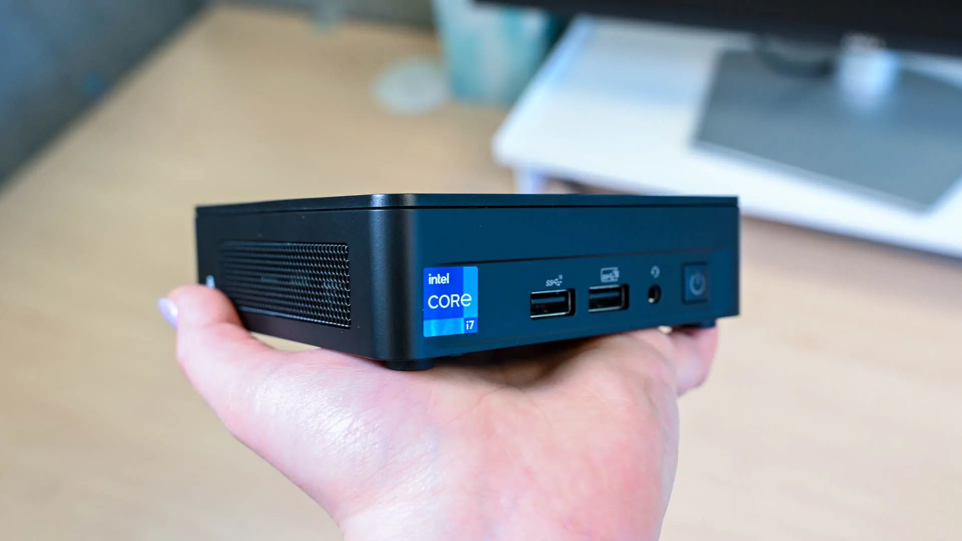 Một người đang cầm trên tay chiếc Mini PC Intel NUC 13 Pro, làm nổi bật kích thước nhỏ gọn của thiết bị.
