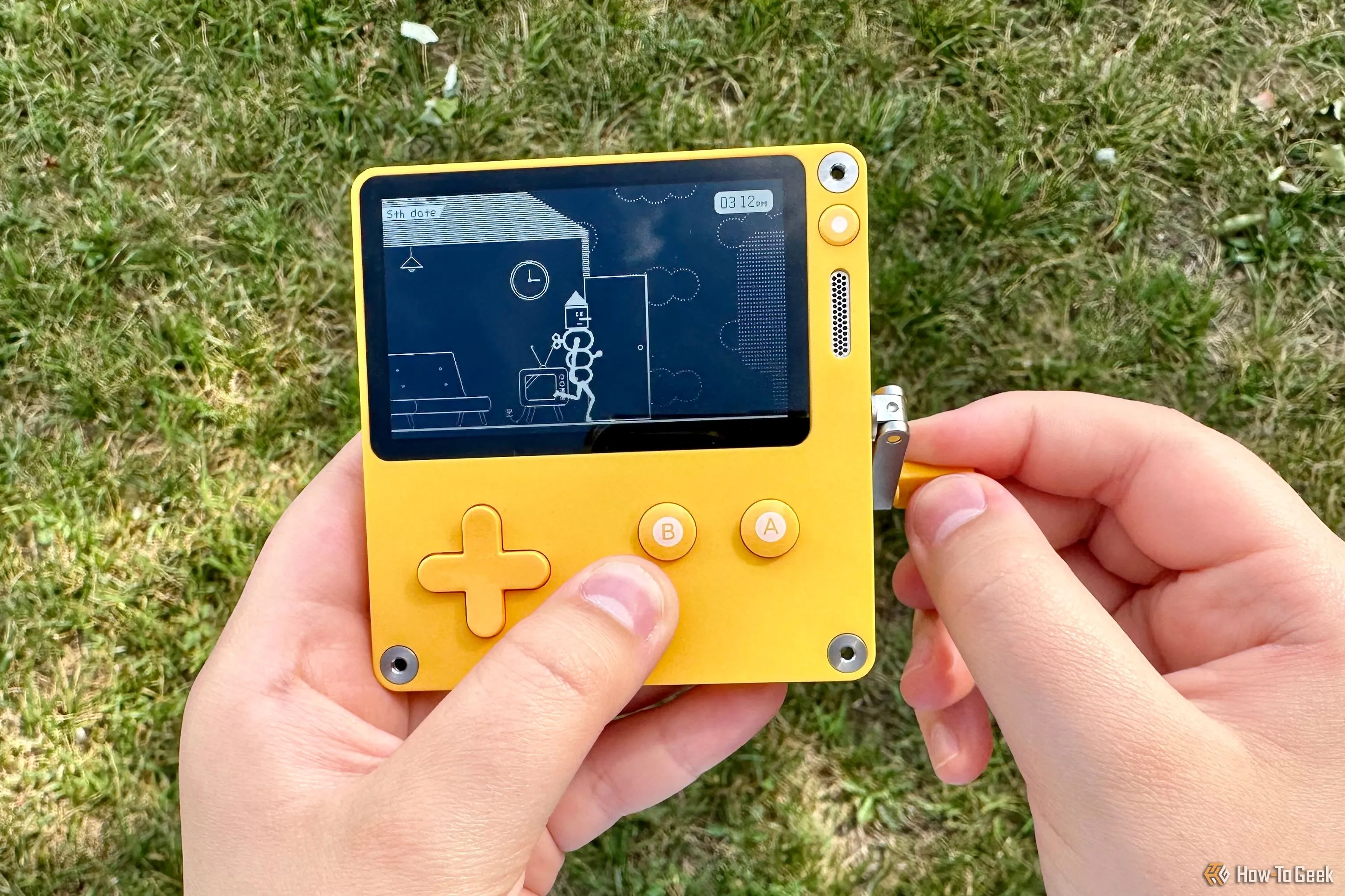 Một người đang trải nghiệm chơi game trên máy Playdate, sử dụng tay quay độc đáo