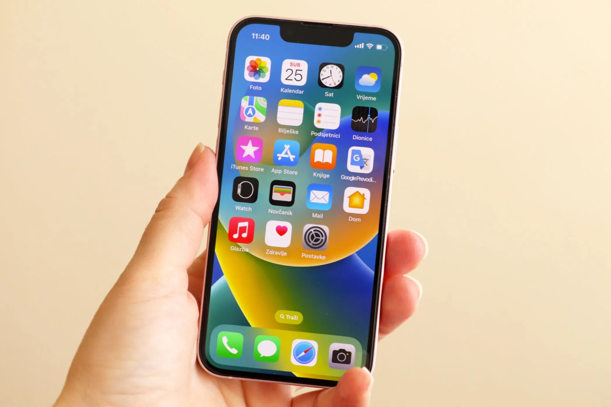 Một người phụ nữ đang cầm chiếc iPhone 13 Mini màu xanh lá cây, thể hiện kích thước nhỏ gọn dễ sử dụng bằng một tay.