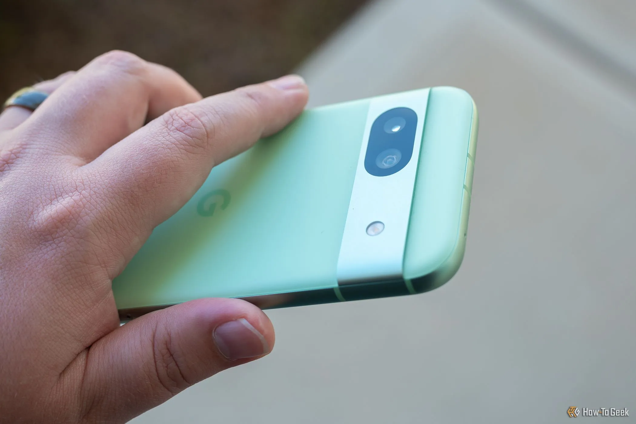 Người dùng cầm điện thoại Google Pixel 8a, nhìn rõ cụm camera sau.