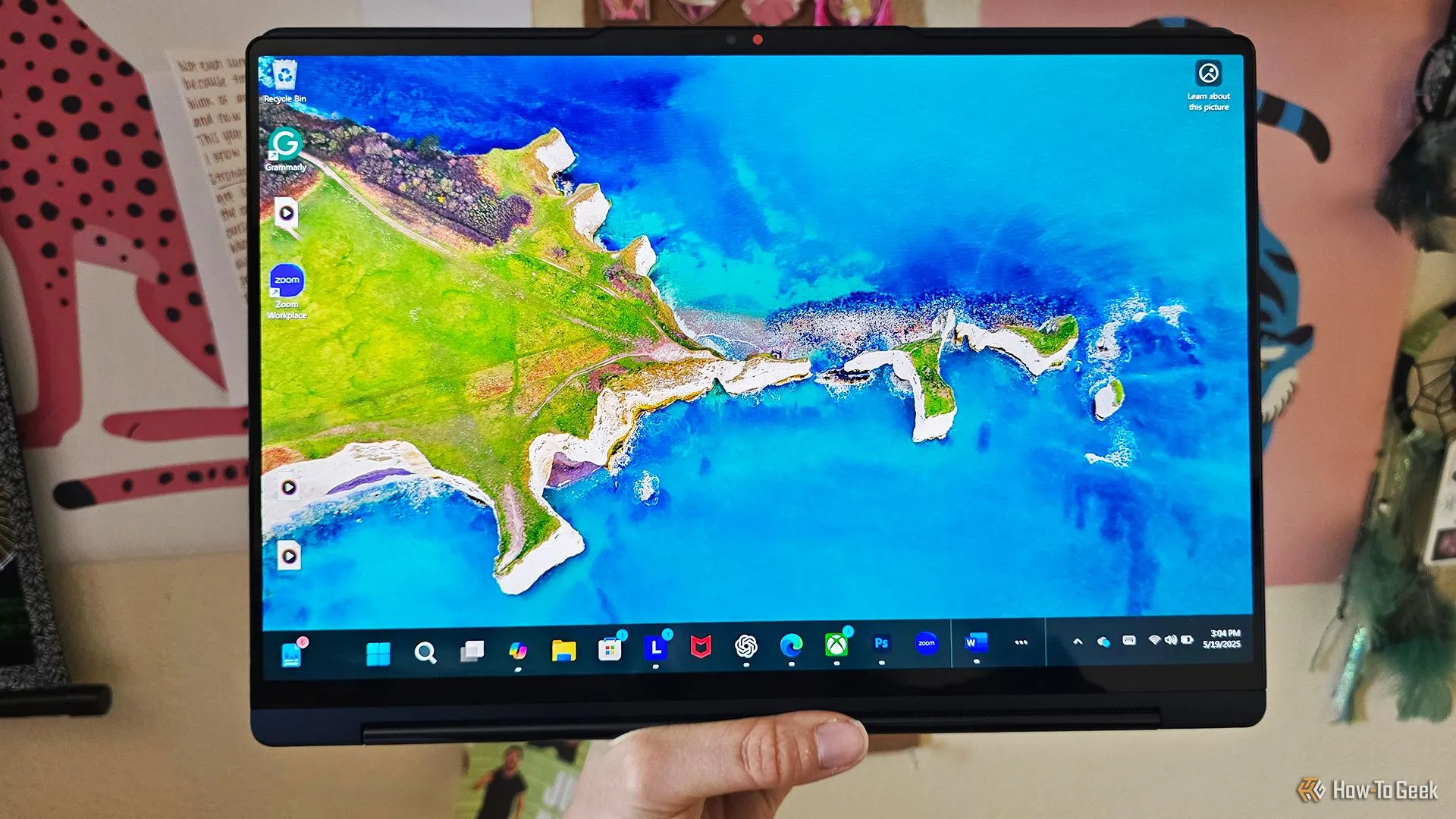 Người dùng cầm laptop Lenovo Yoga 9i 2-in-1 Gen 10 ở chế độ máy tính bảng.
