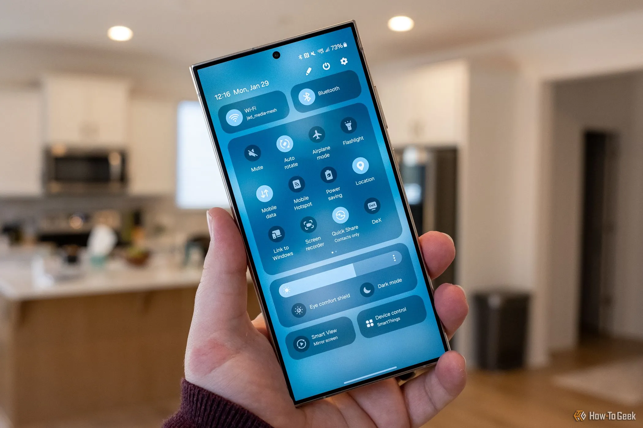 Người dùng cầm Samsung Galaxy S24 Ultra, hiển thị menu cài đặt nhanh hoặc bảng điều khiển cạnh, minh họa tính năng đa nhiệm One UI.
