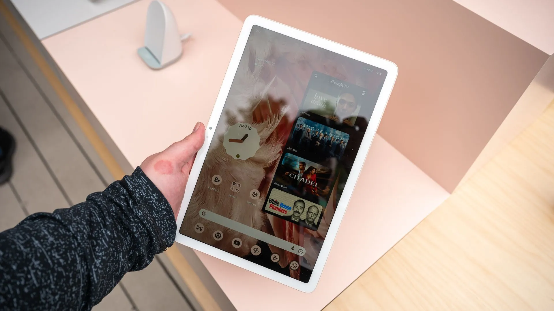 Người dùng đang cầm Google Pixel Tablet theo chiều dọc, hiển thị giao diện Android