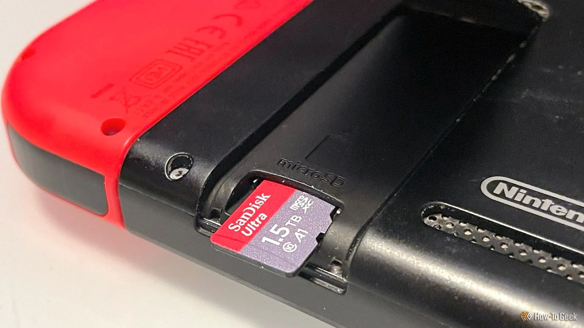 Người dùng đang cắm thẻ nhớ microSD vào khe cắm trên máy chơi game Nintendo Switch, giải pháp mở rộng dung lượng lưu trữ.