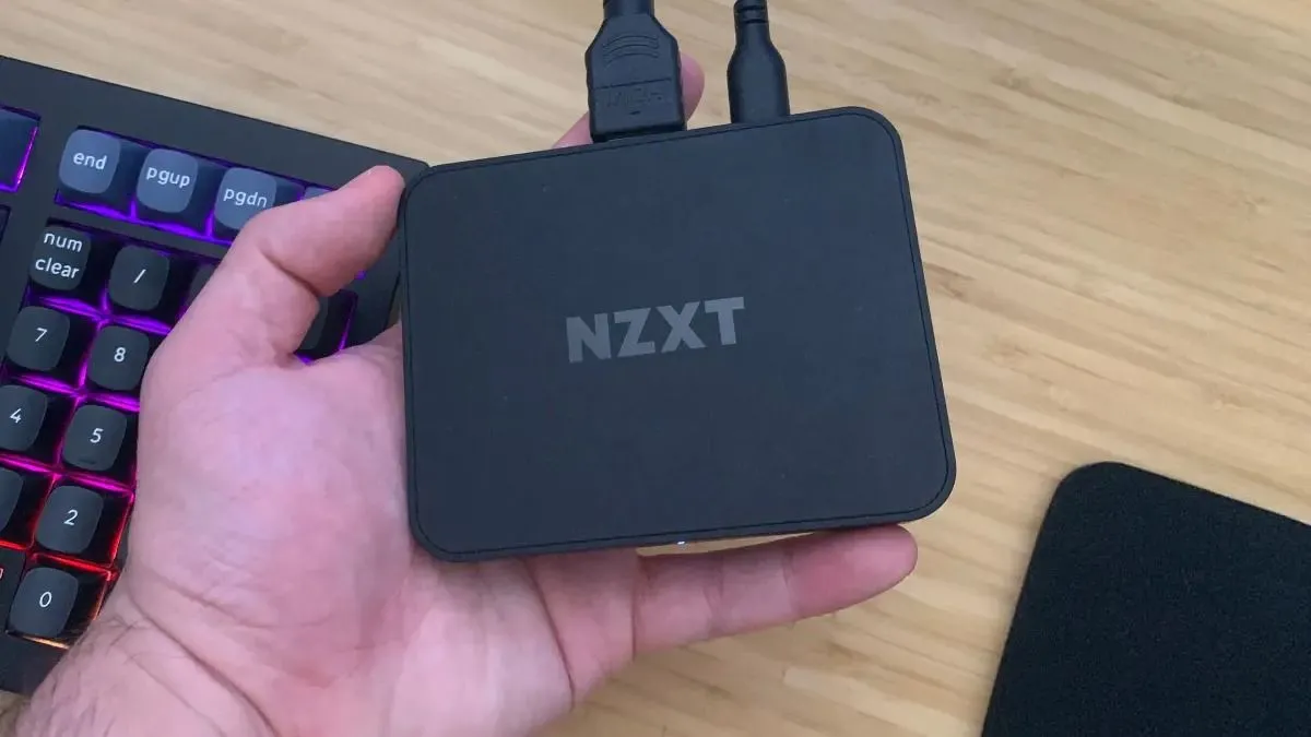 Người dùng đang cầm thiết bị capture card NZXT Signal 4K30 chuyên dụng, hỗ trợ ghi hình gameplay chất lượng cao.