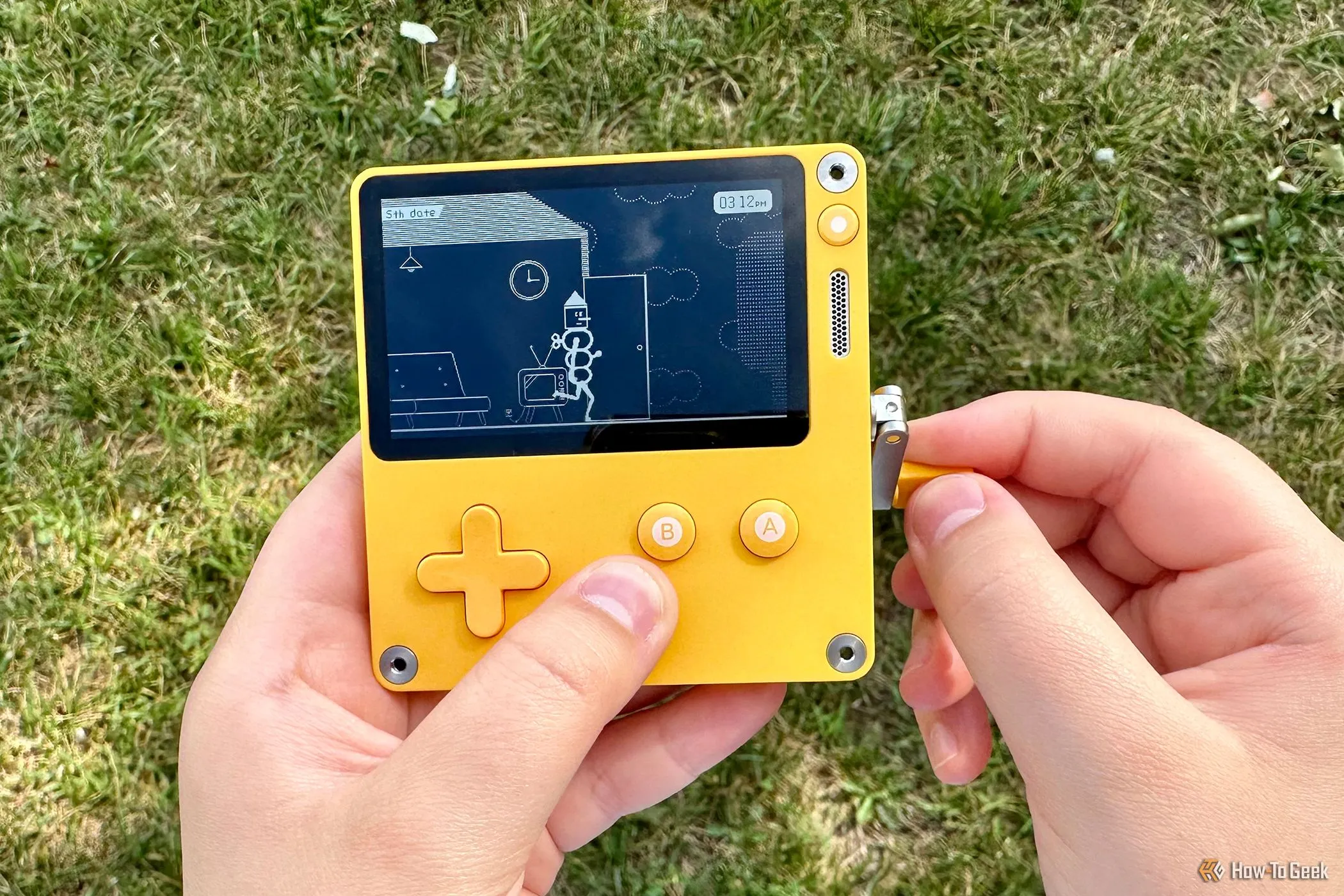 Người dùng đang trải nghiệm máy chơi game cầm tay Playdate với màn hình đơn sắc và tay quay đặc trưng