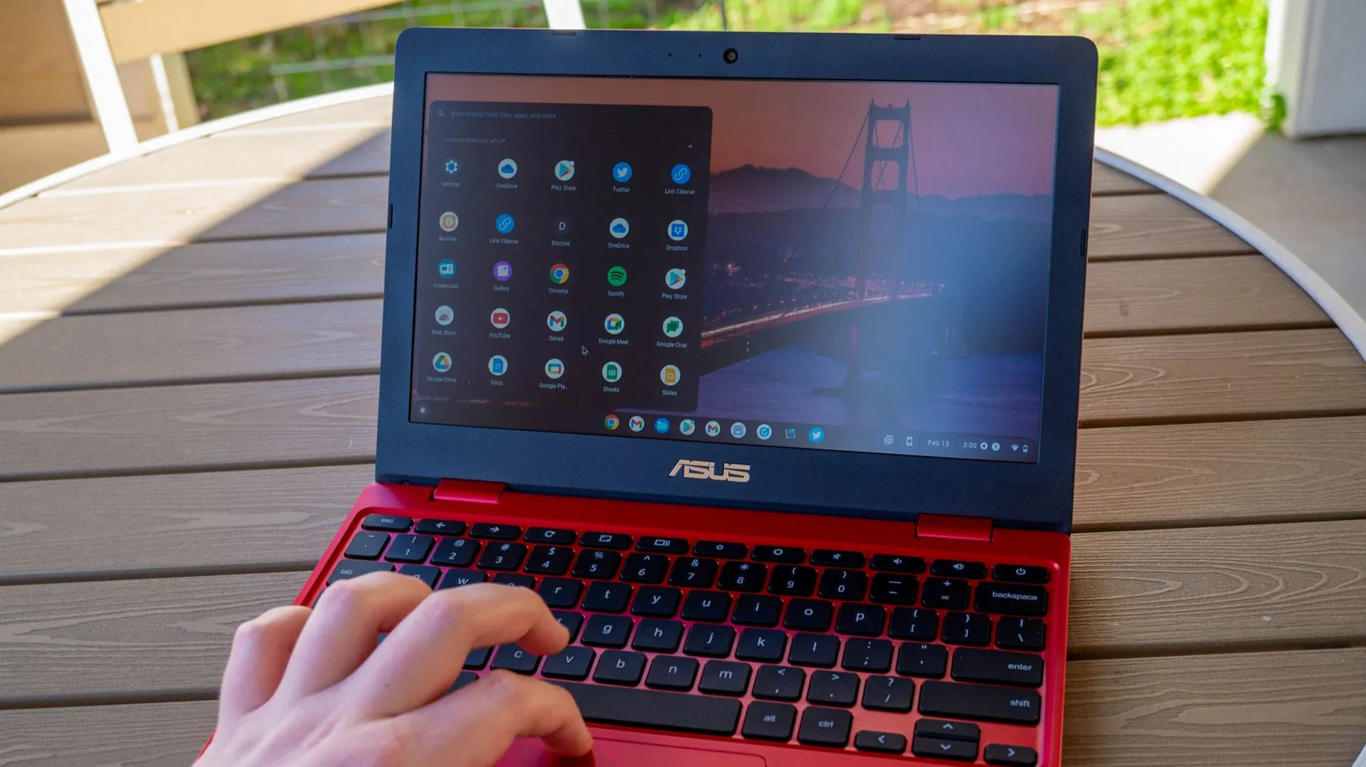 Người dùng làm việc với laptop ASUS Chromebook 12 đặt trên bàn ngoài trời