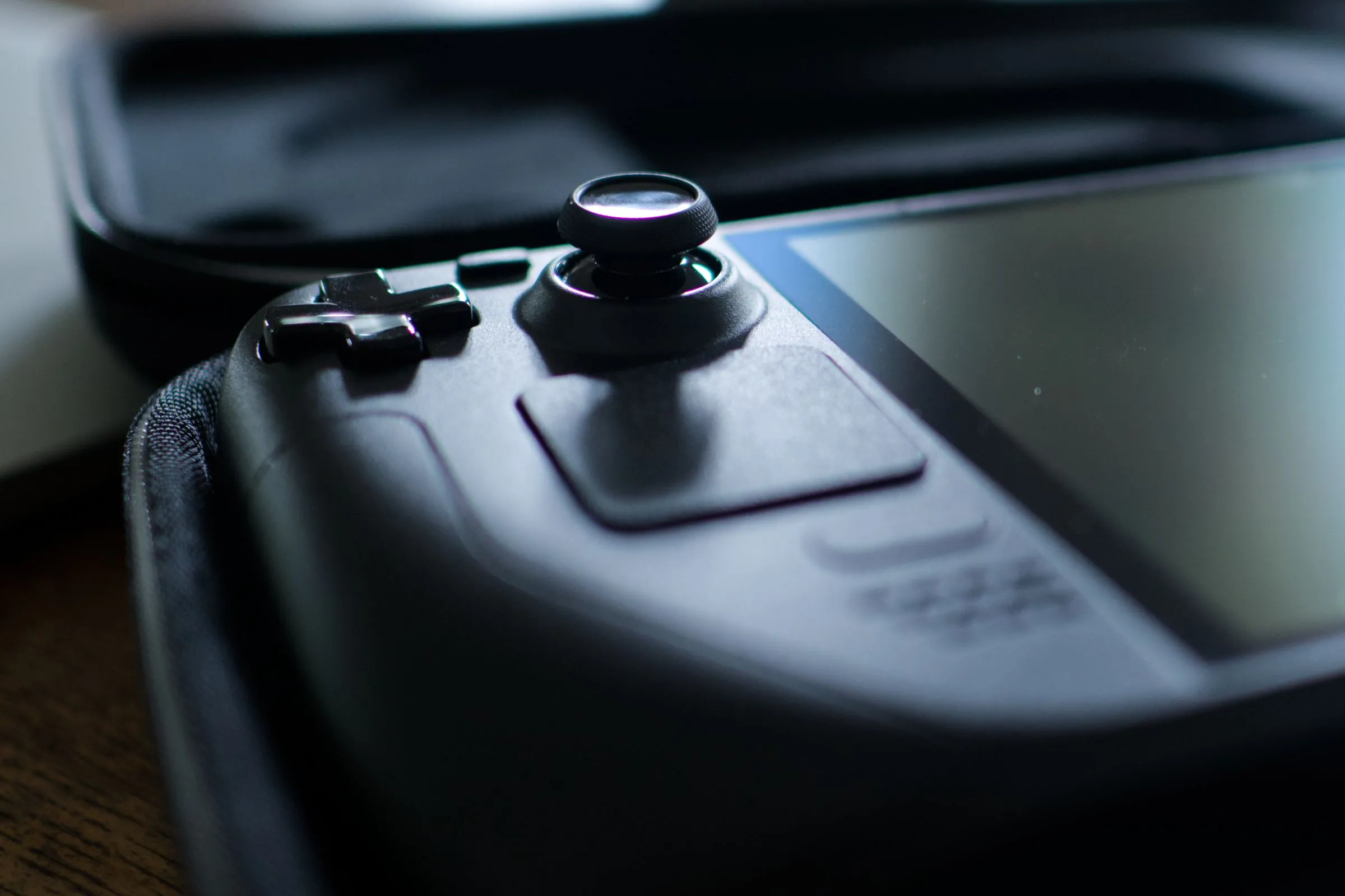 Steam Deck OLED trong hộp đựng với joystick trái đang được lấy nét