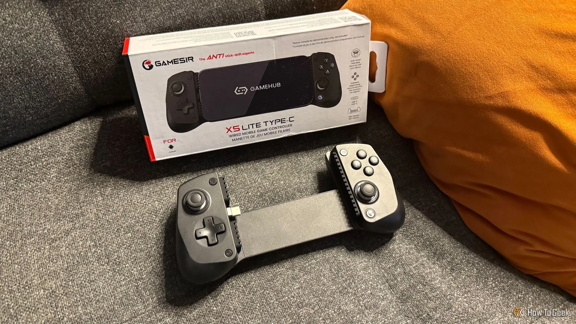 Tay cầm chơi game di động GameSir X5 Lite và hộp sản phẩm trên ghế sofa