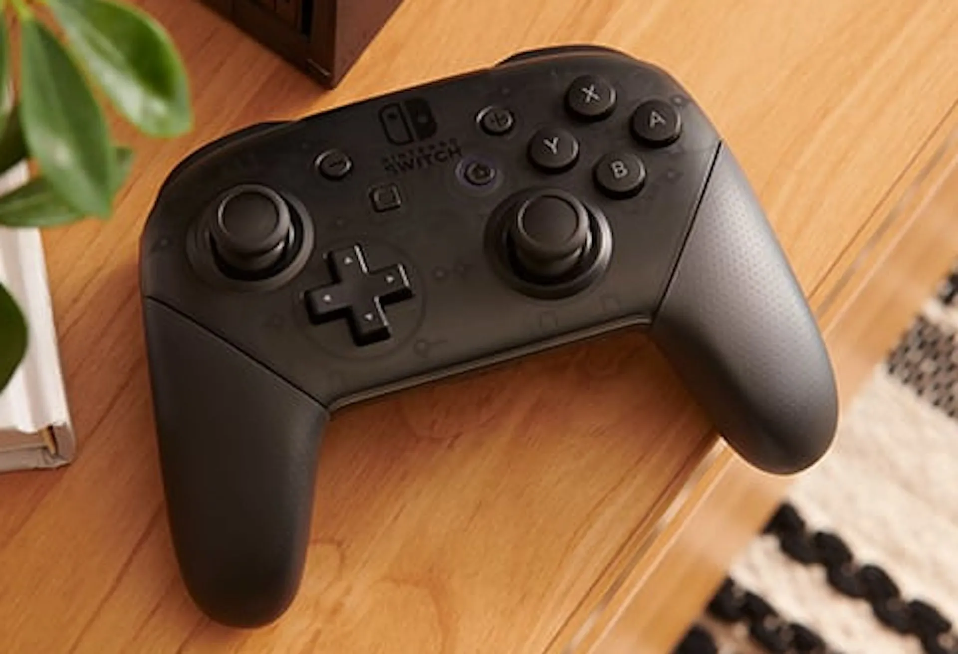 Tay cầm Nintendo Switch Pro Controller màu đen đặt trên bàn gỗ, biểu tượng của trải nghiệm chơi game console chuyên nghiệp.