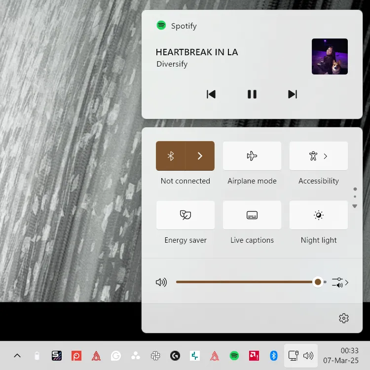 Ảnh chụp màn hình Windows 11 Action Center, hiển thị trình phát Spotify và vị trí mới của điều khiển media.
