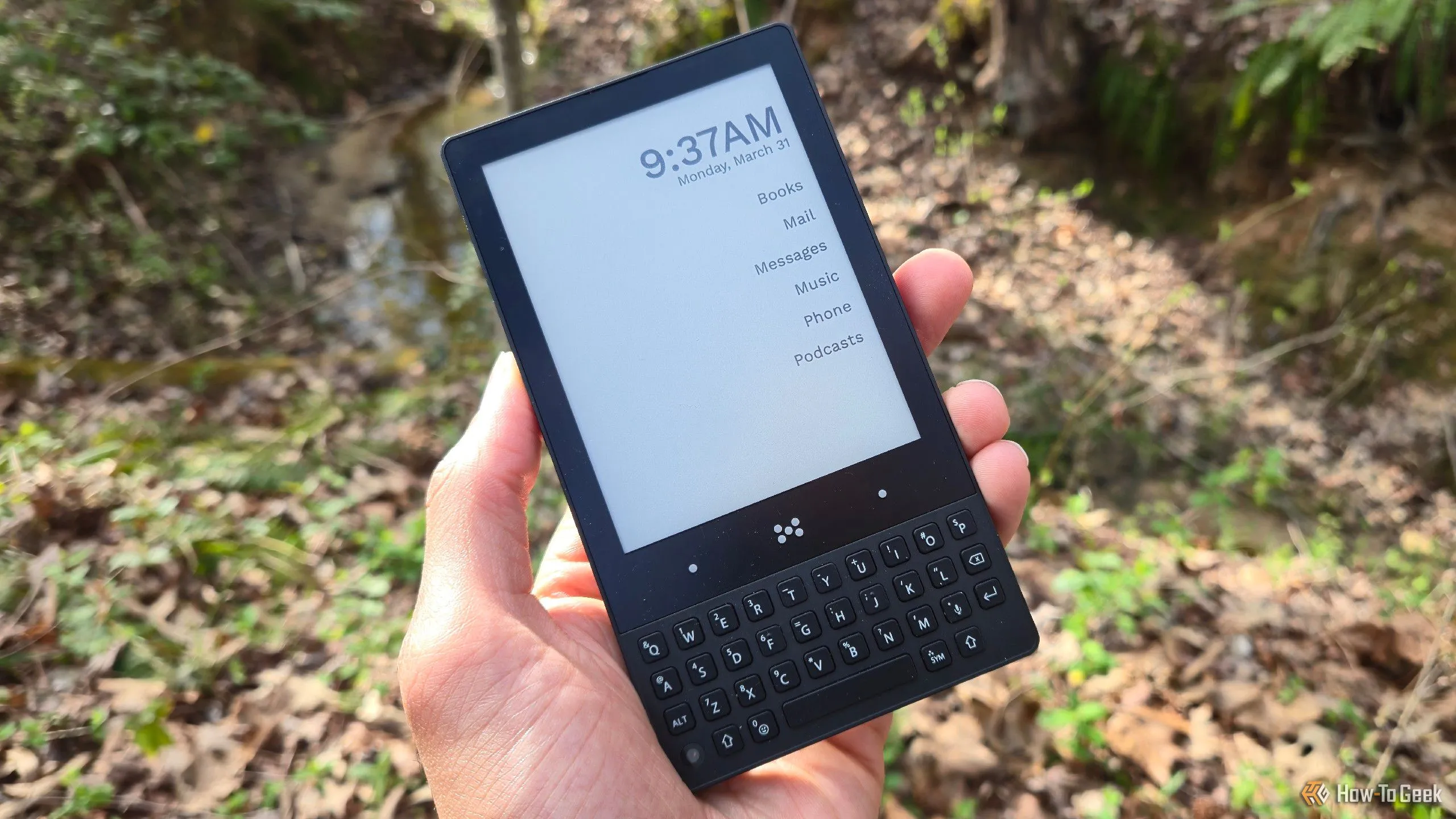 Bàn tay cầm Minimal Phone màu đen, hiển thị màn hình E Ink và thiết kế nhỏ gọn.