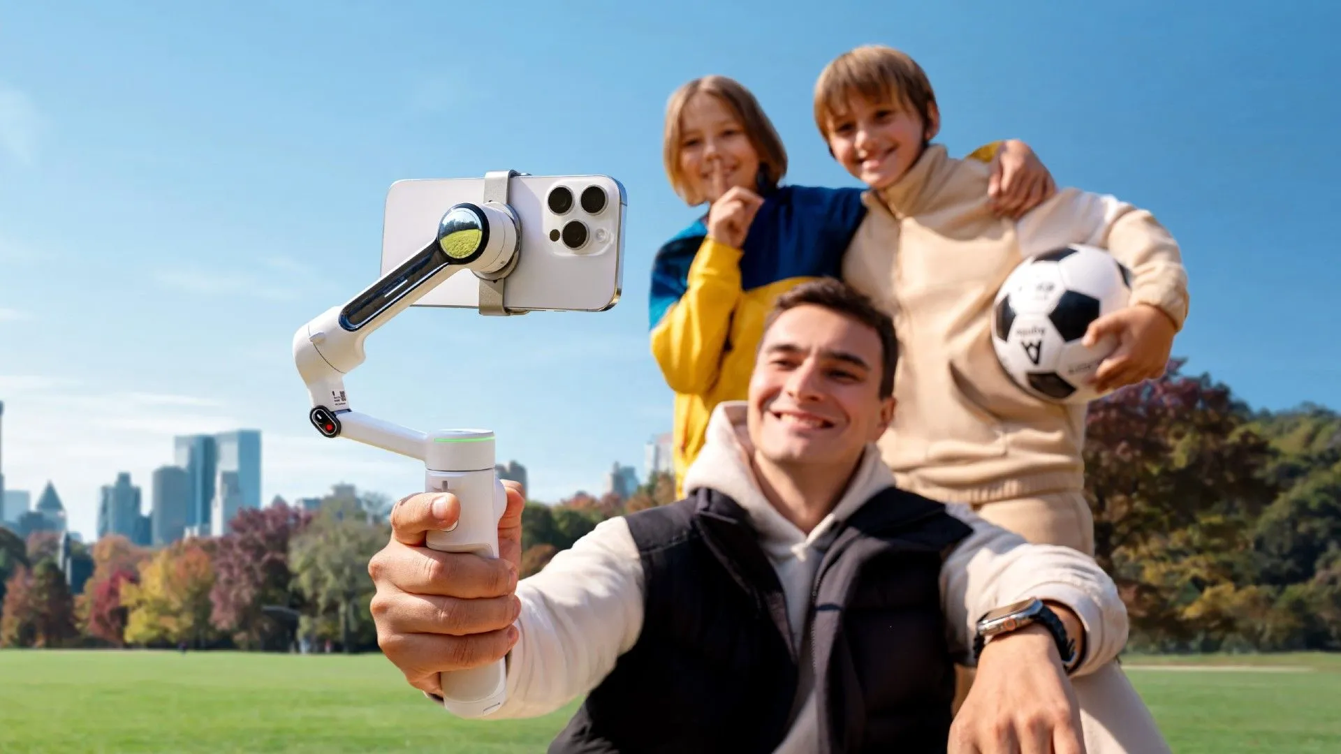 Bộ ổn định Insta360 Flow 2 Pro đang theo dõi và quay phim một nhóm người đi bộ và gia đình chơi bóng.