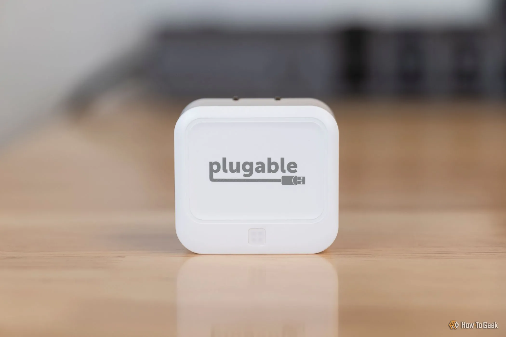 Bộ sạc Plugable 40W USB-C kép đặt gọn gàng trên mặt bàn, làm nổi bật tính di động và dễ dàng mang theo khi du lịch.