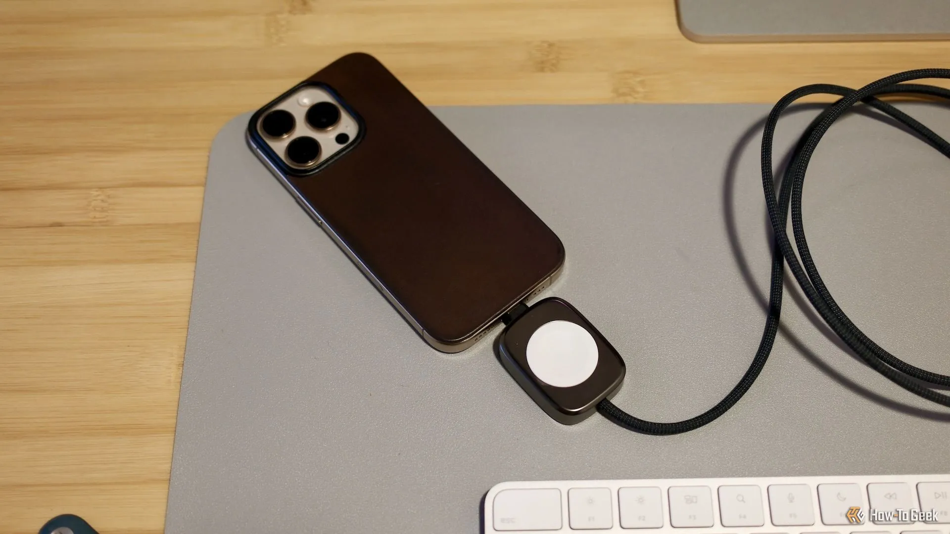 Cáp Nomad sạc Apple Watch và USB-C đặt trên bàn làm việc, thể hiện sự gọn gàng tiện lợi