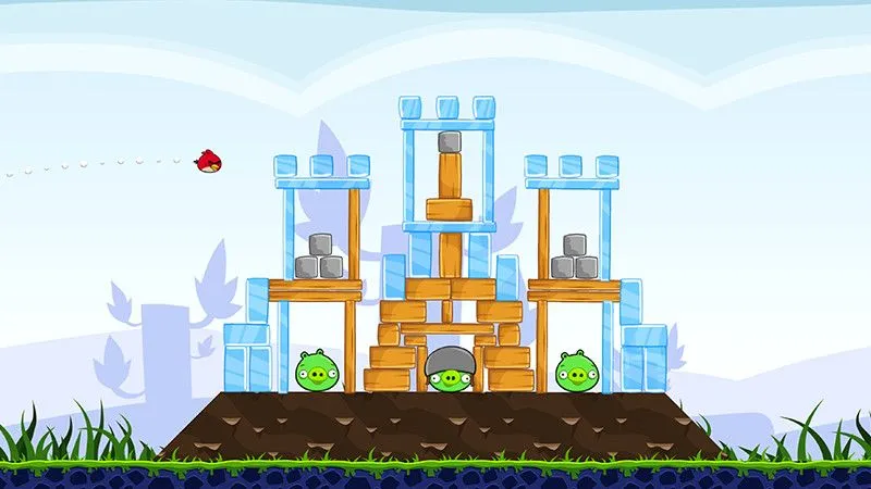 Chú chim đỏ của Angry Birds đang được phóng đi trên màn hình điện thoại, chuẩn bị tấn công công trình của lũ lợn xanh, minh họa lối chơi đặc trưng.