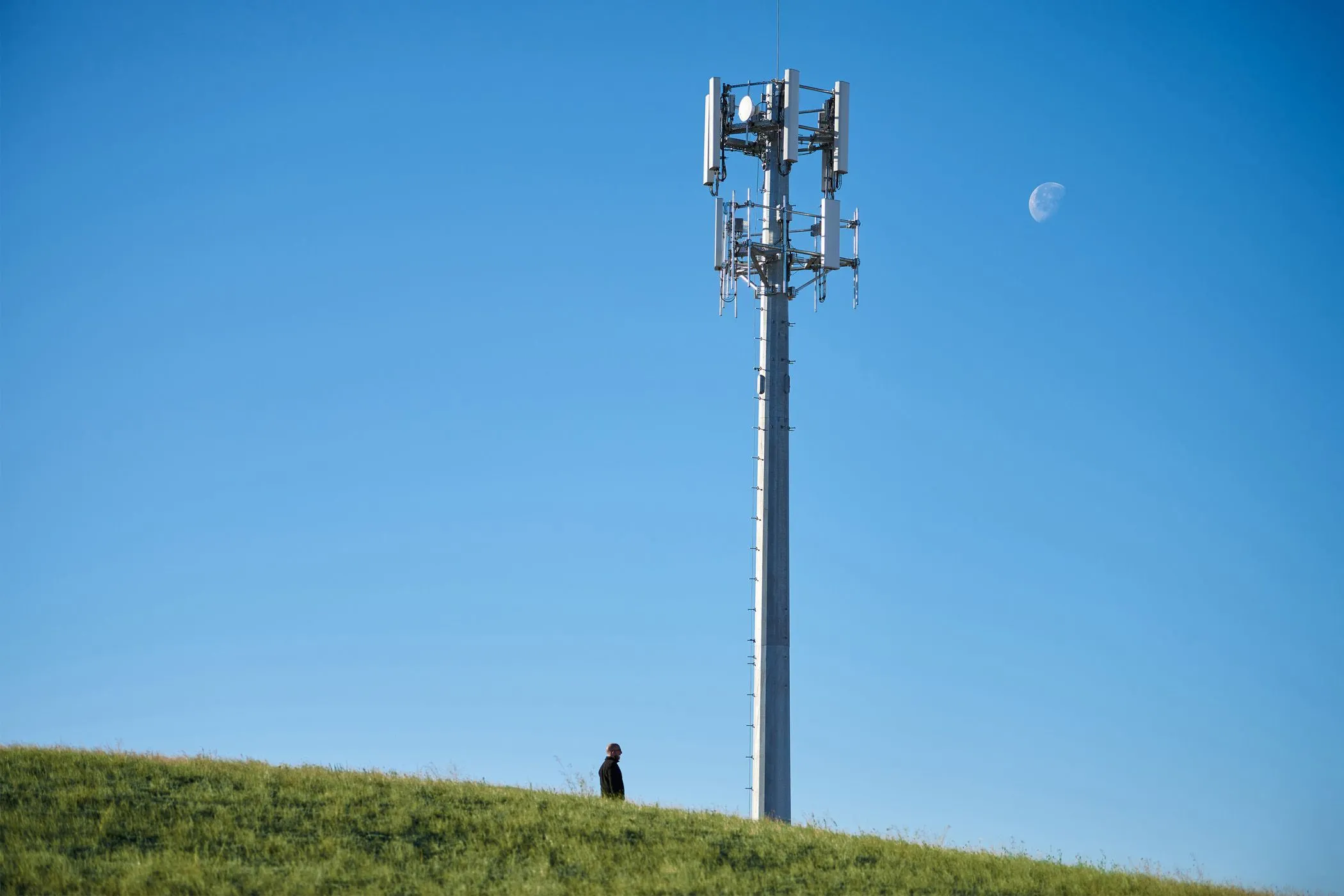 Cột thu phát sóng di động 5G trên đồi, thể hiện cách tín hiệu lan truyền ảnh hưởng đến vùng phủ sóng mạng.