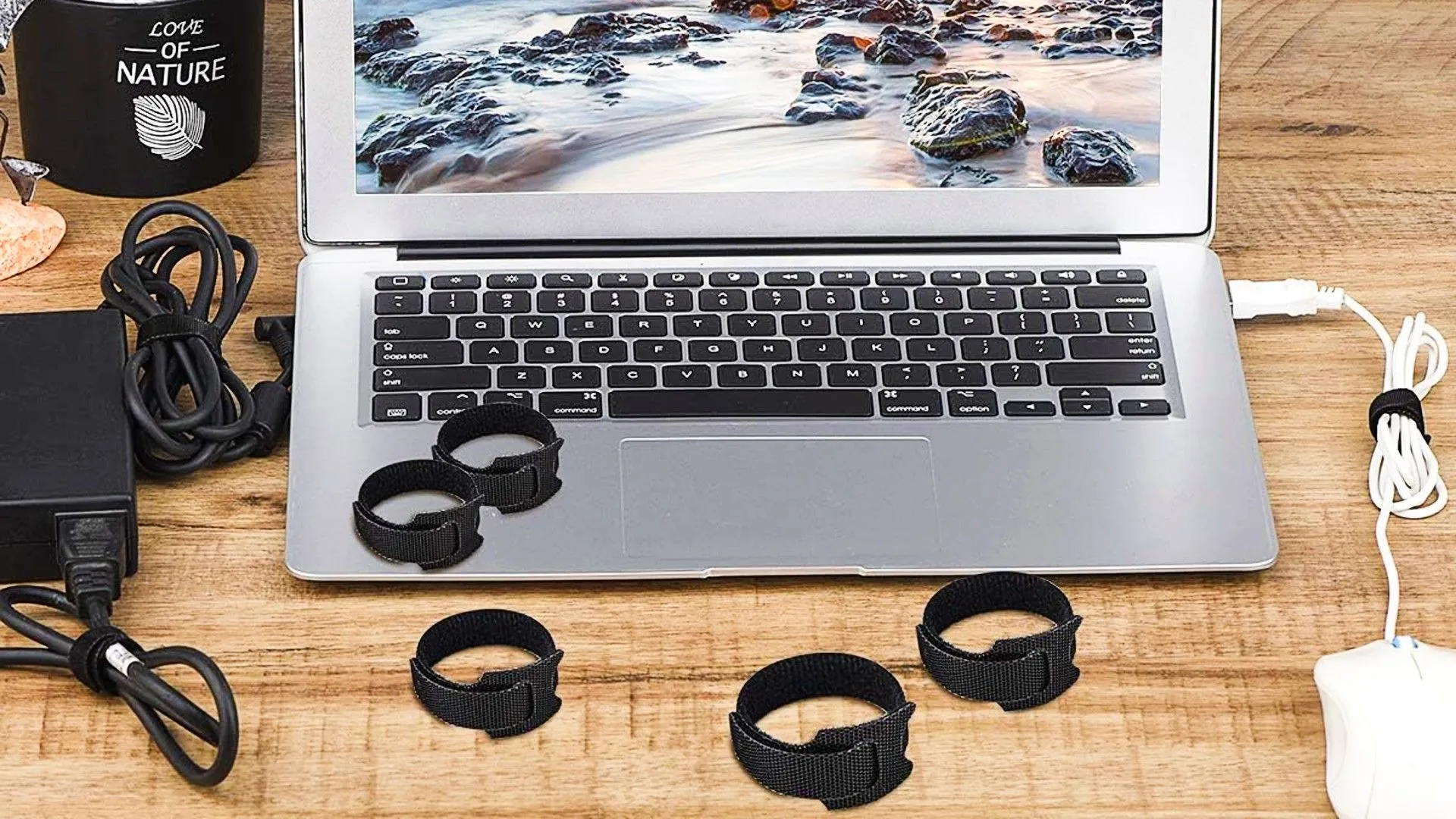 Dây buộc cáp đang quấn quanh một laptop, giúp giữ cho các loại dây điện gọn gàng và ngăn nắp.