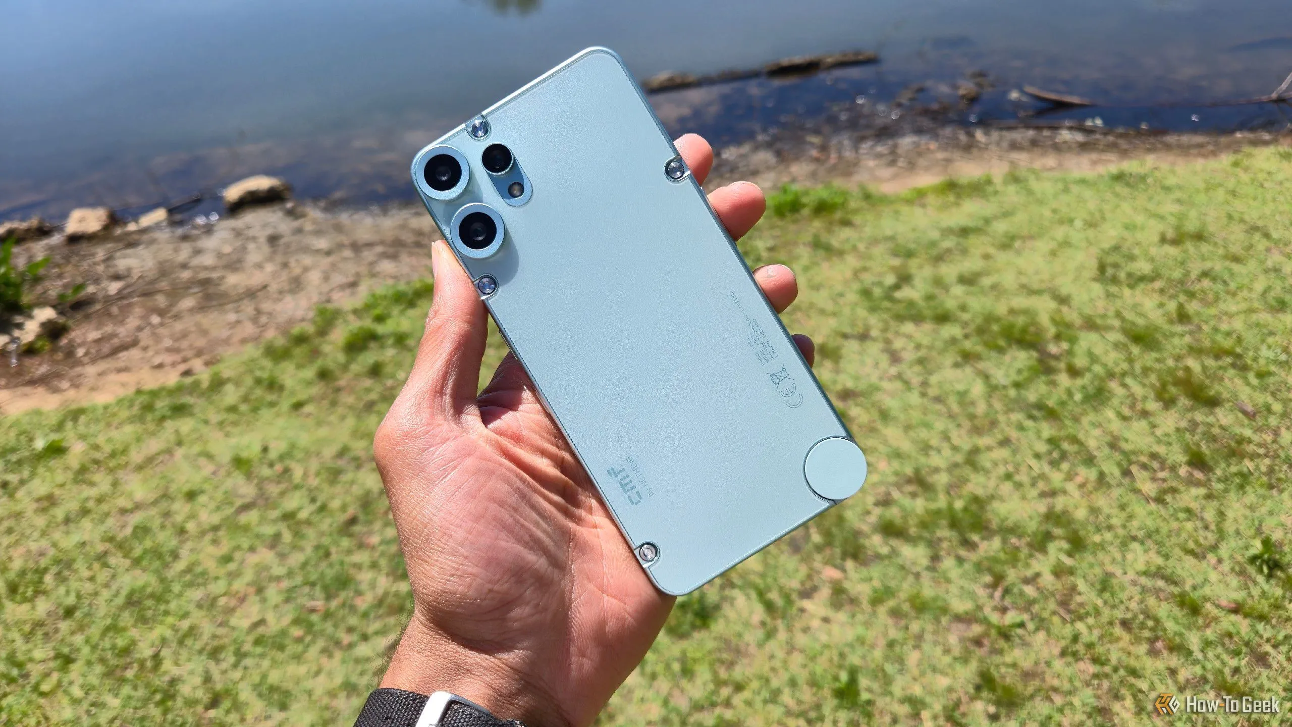 Điện thoại CMF Phone 2 Pro màu đen nổi bật trên nền một hồ nước, thể hiện thiết kế tối giản và hiện đại.
