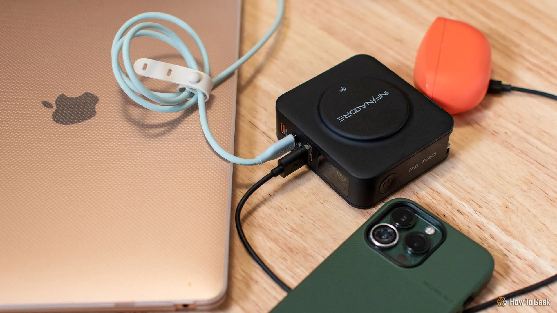InfinaCore P3 Pro đang sạc đồng thời tai nghe không dây, MacBook và iPhone qua các cổng USB cùng sạc không dây Qi2