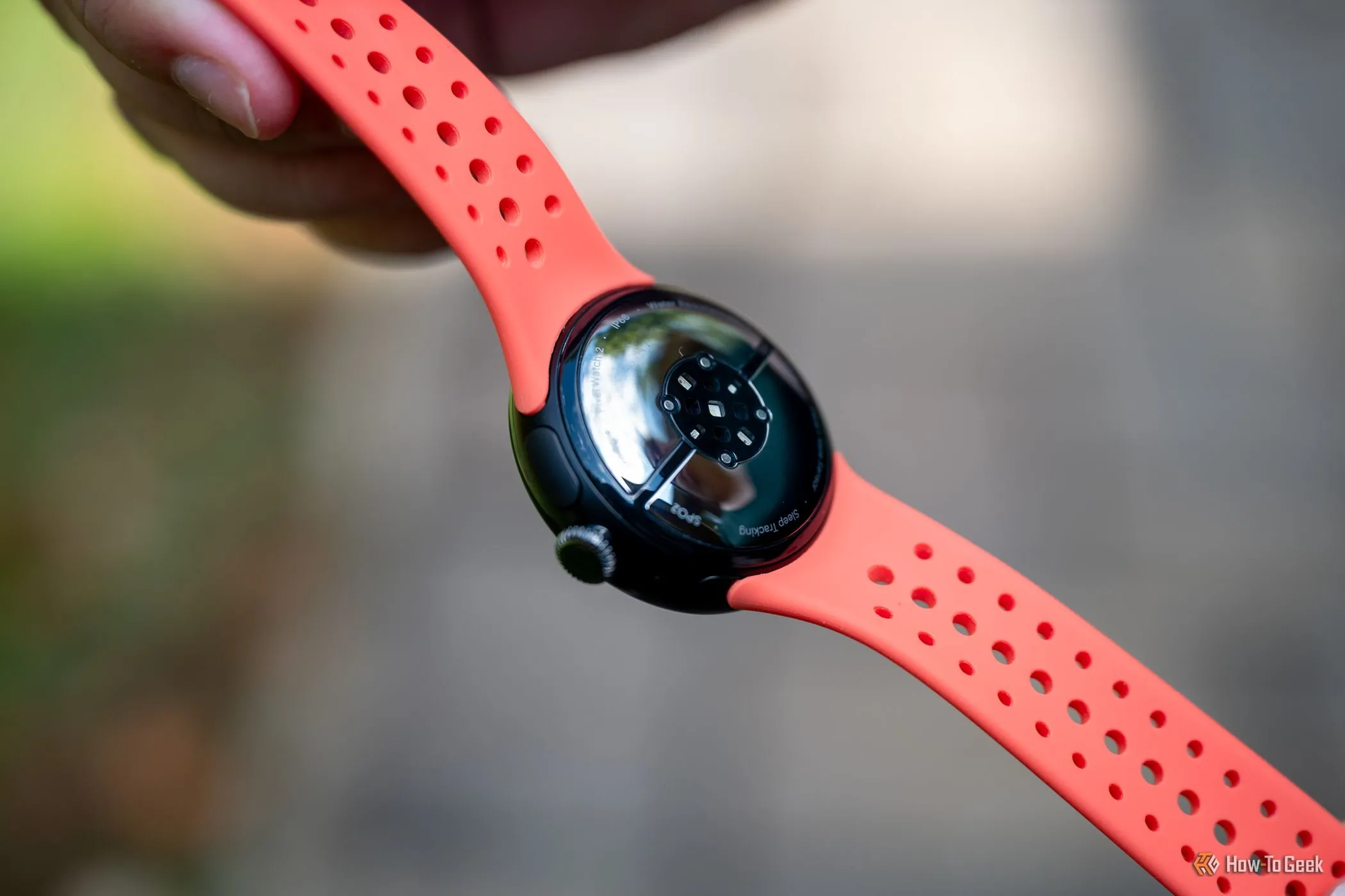 Mặt dưới của Google Pixel Watch 2 với các miếng sạc và cảm biến nhịp tim.