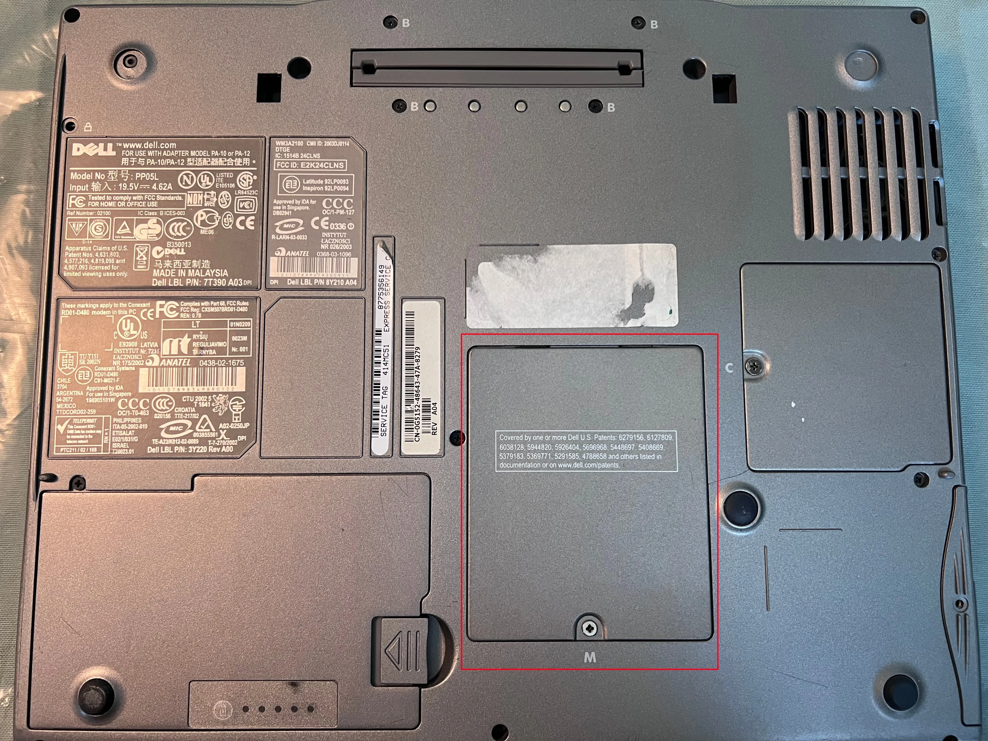 Mặt dưới của laptop Dell với nắp truy cập RAM được đánh dấu màu đỏ