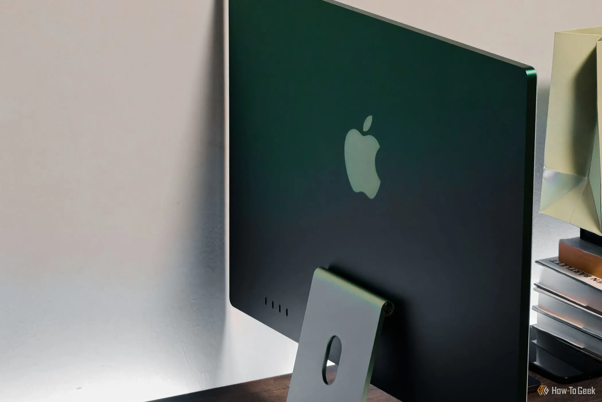 Mặt sau tinh tế của iMac M4 màu xanh lá được nhìn từ góc nghiêng.