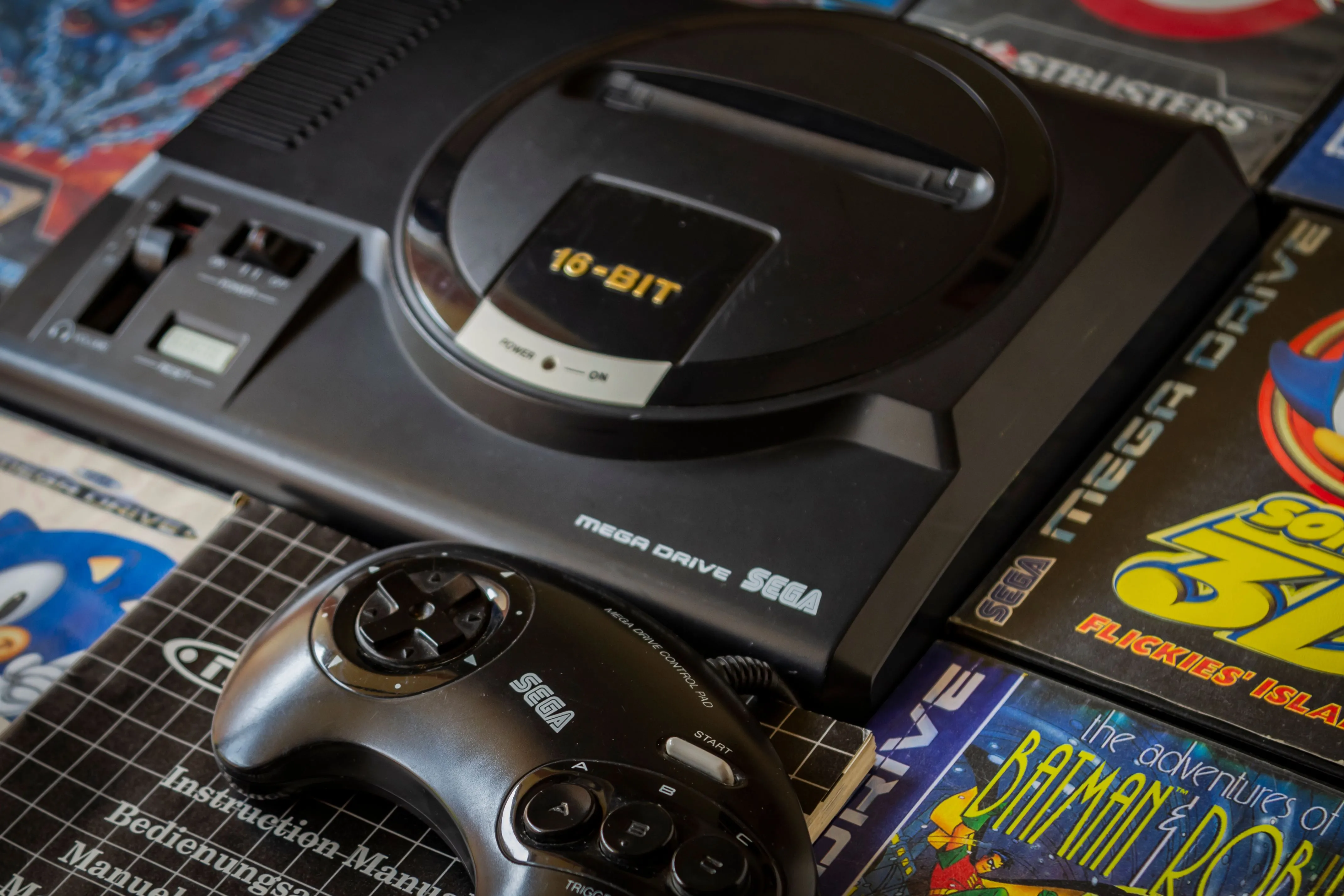 Máy console Sega Genesis cùng các băng game và tay cầm, nơi cáp Link-up mở ra tiềm năng multiplayer.