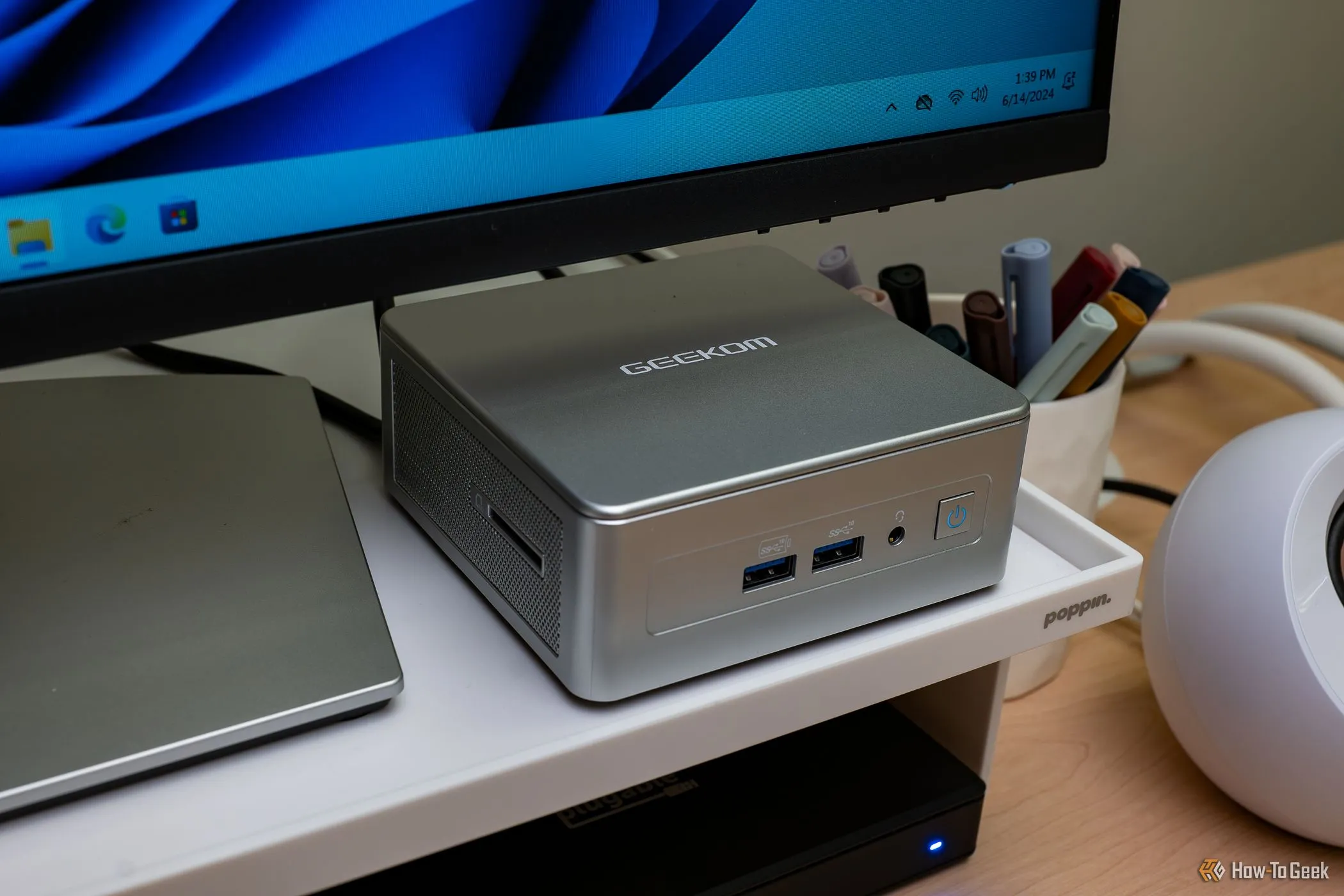 Máy tính mini GEEKOM AE7 trên bàn làm việc gọn gàng, thể hiện sự nhỏ gọn của mini PC