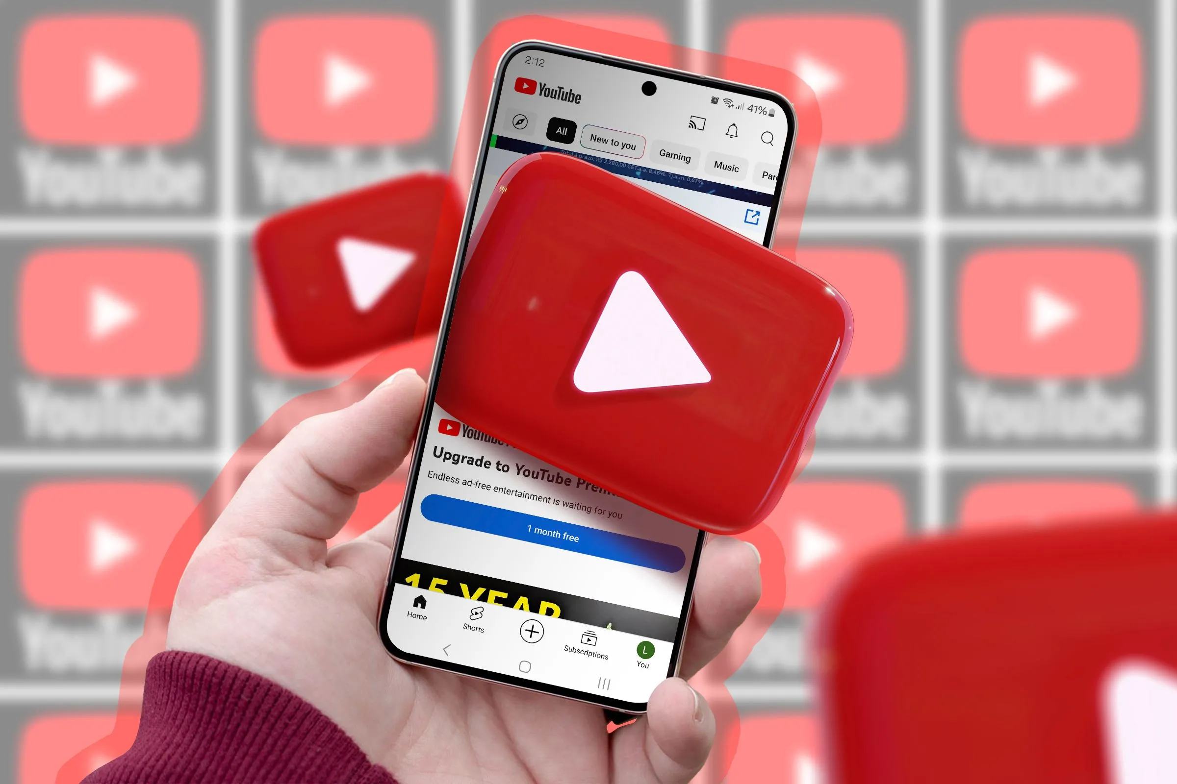 Một bàn tay cầm điện thoại di động hiển thị biểu tượng YouTube, tượng trưng cho trải nghiệm nghe nhạc và tính năng playlist cộng tác mới trên YouTube.