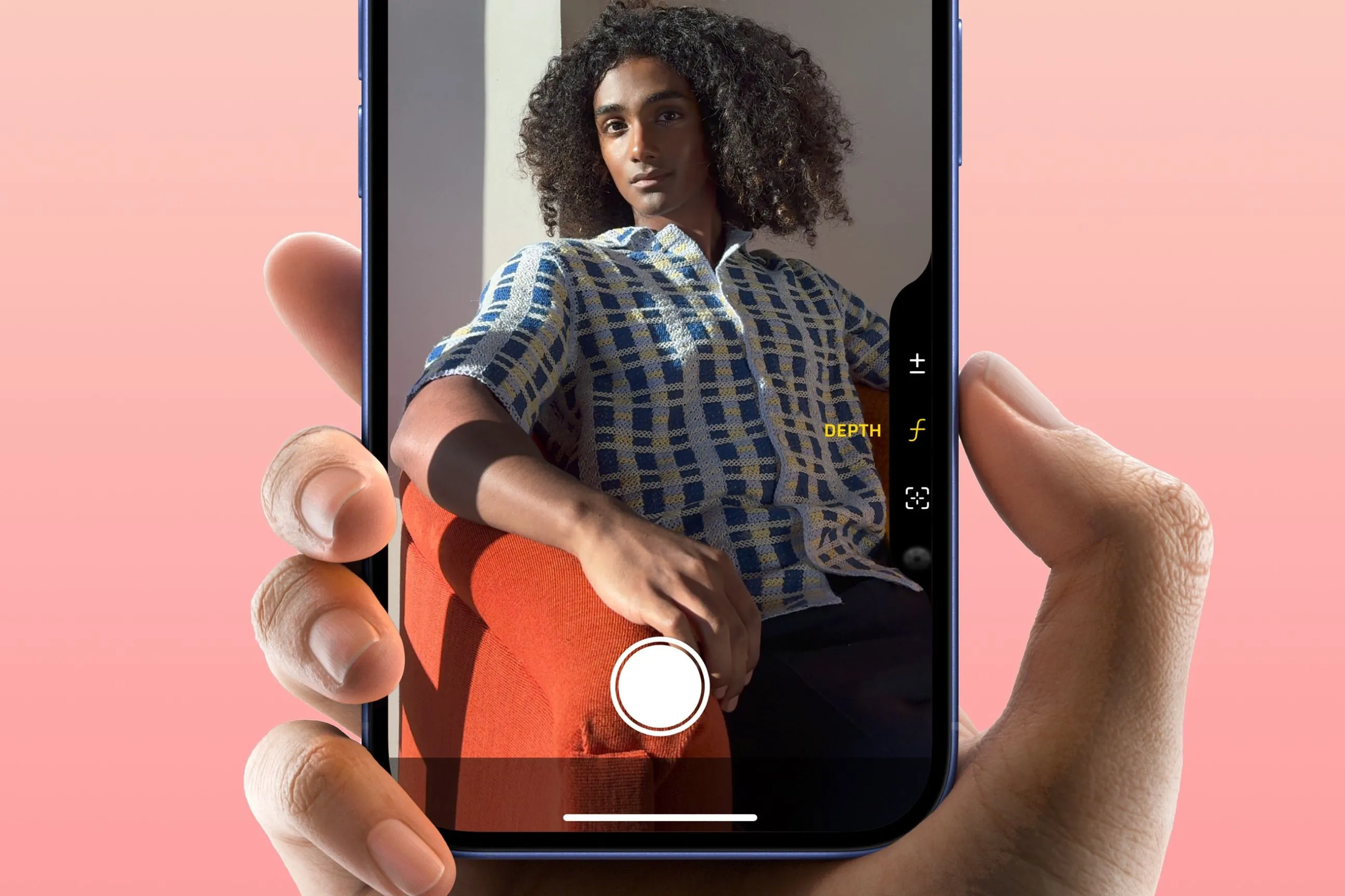 Một bàn tay đang giữ iPhone 16 và ngón trỏ nhấn vào nút chụp Camera Control, minh họa sự tiện lợi và quen thuộc khi sử dụng tính năng này sau thời gian dài.