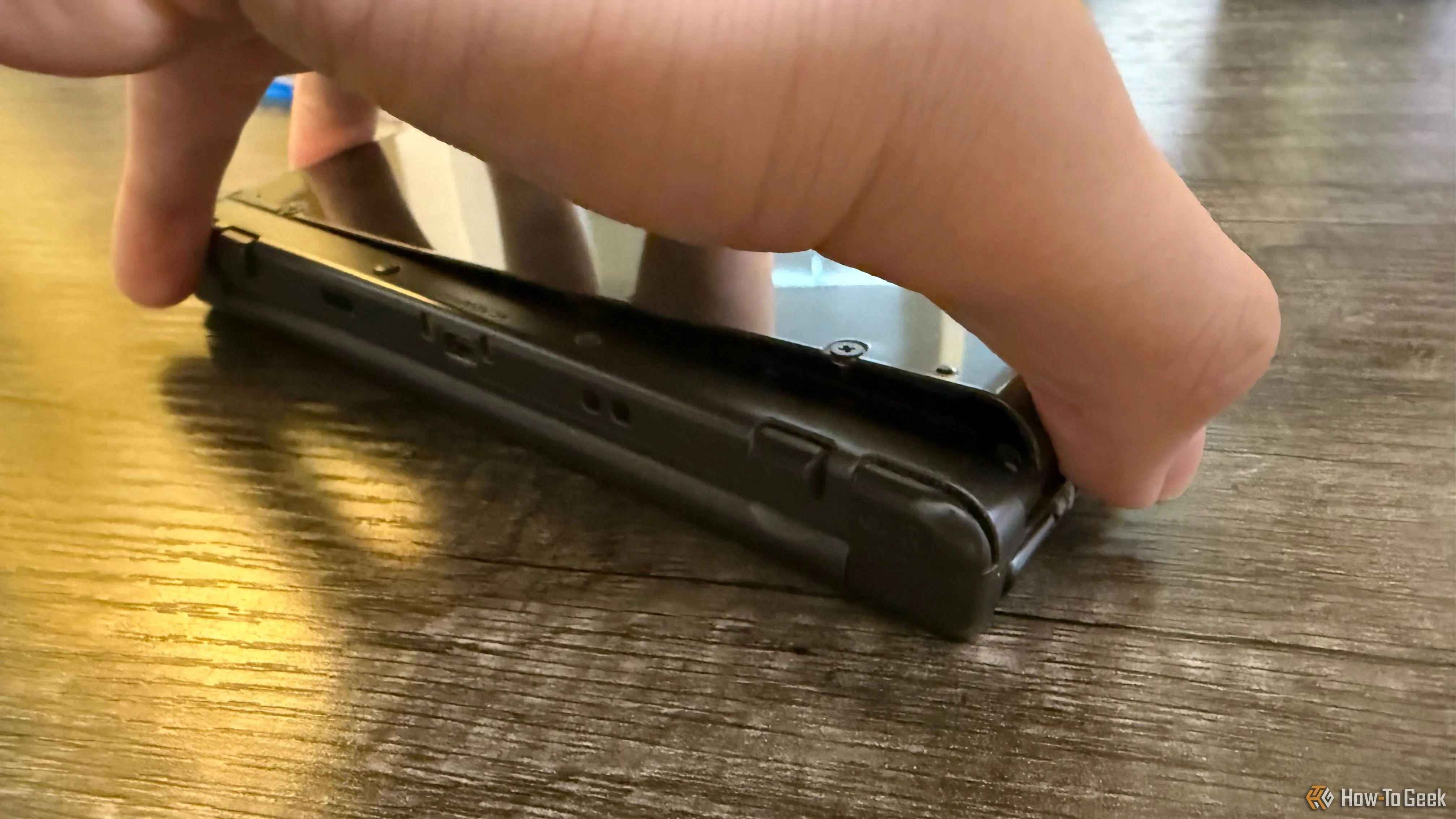 Một bàn tay đang nhẹ nhàng tháo ốp lưng của New Nintendo 3DS XL