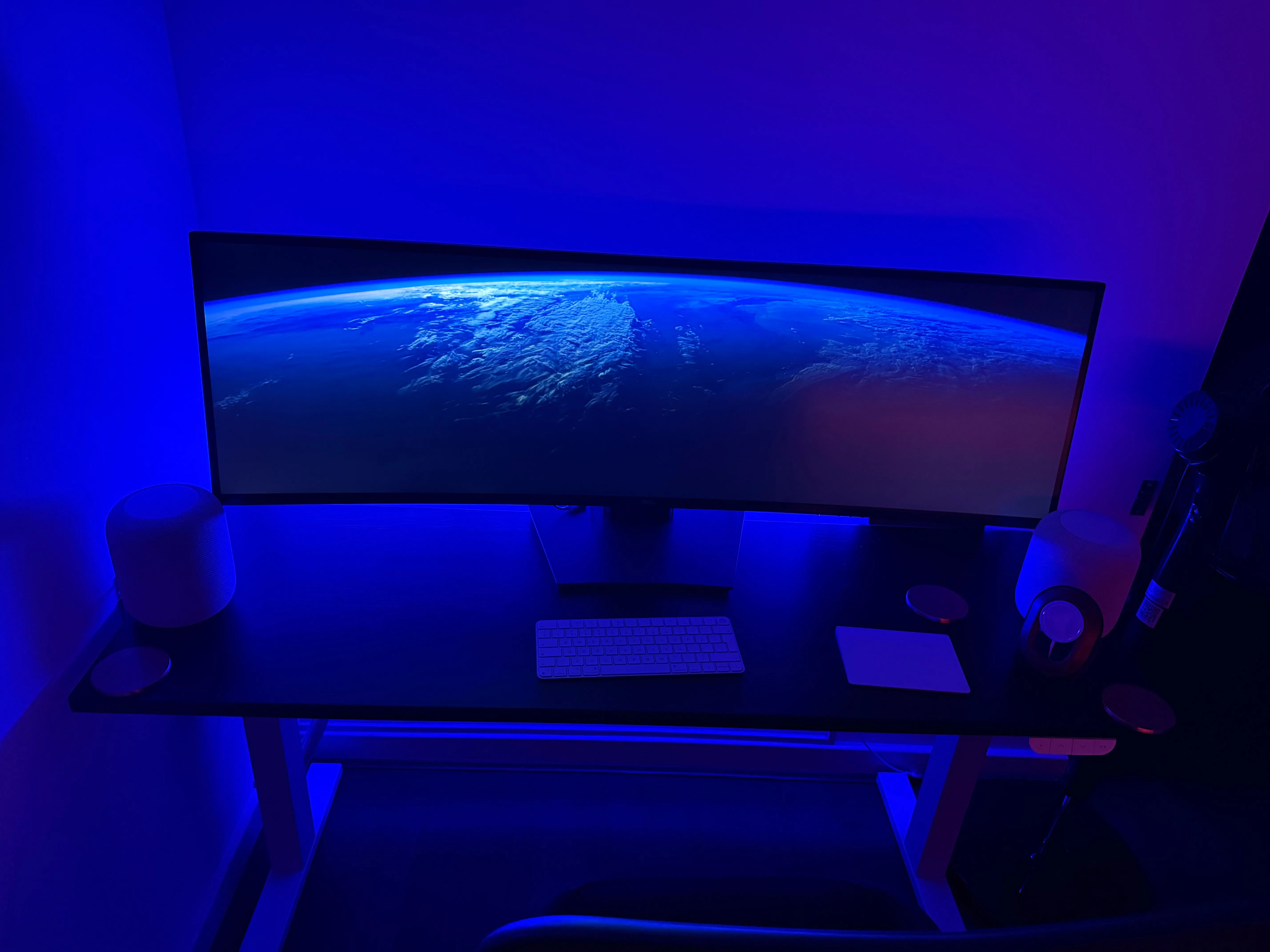 Một không gian văn phòng tại nhà với đèn dải Philips Hue phía sau bàn làm việc tạo ra ánh sáng xanh lam dịu mát, minh họa cho việc điều chỉnh ánh sáng và màu sắc.