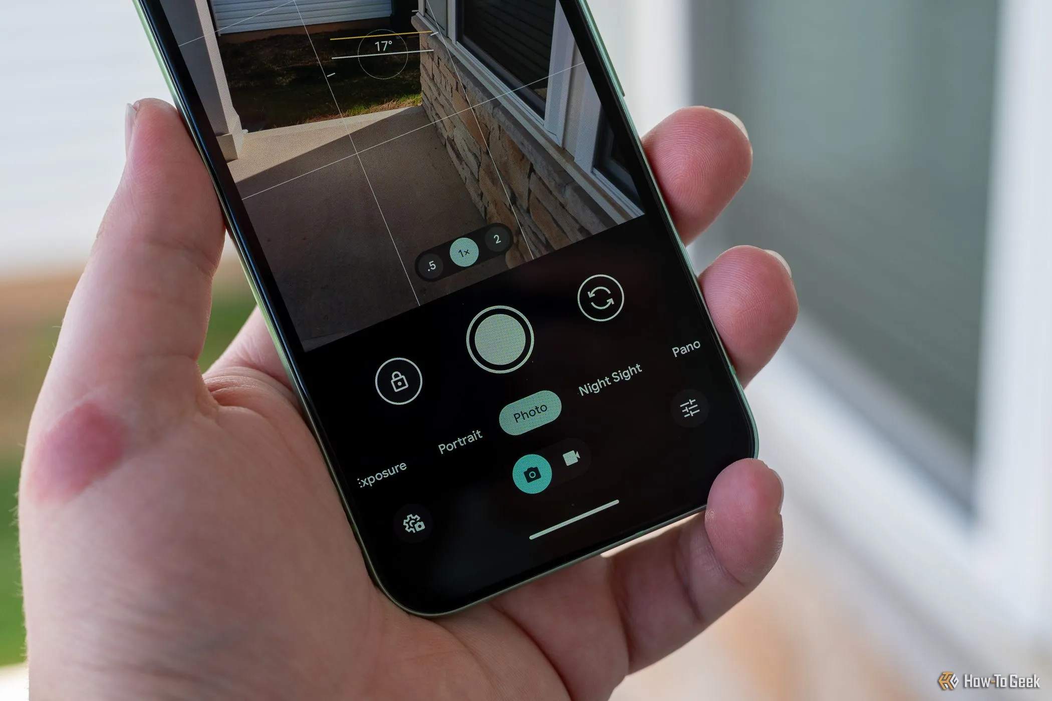 Một người đang cầm Google Pixel 8a, hiển thị giao diện ứng dụng Camera với các tùy chỉnh, nhấn mạnh khả năng chụp ảnh của điện thoại tầm trung.
