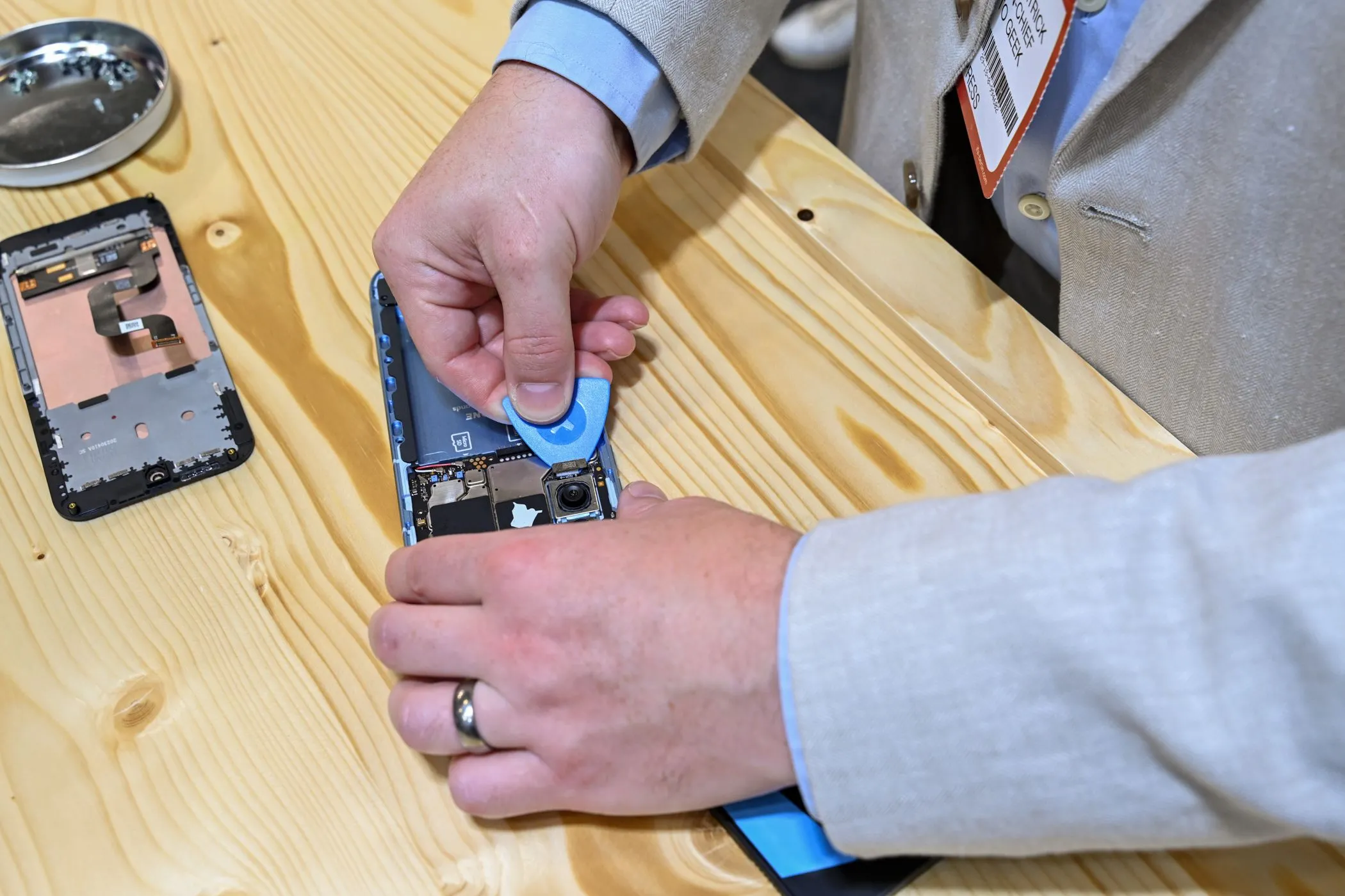 Một người đang tự thay thế linh kiện bên trong chiếc điện thoại Fairphone tại sự kiện IFA 2023, minh họa khả năng sửa chữa dễ dàng và bền vững.