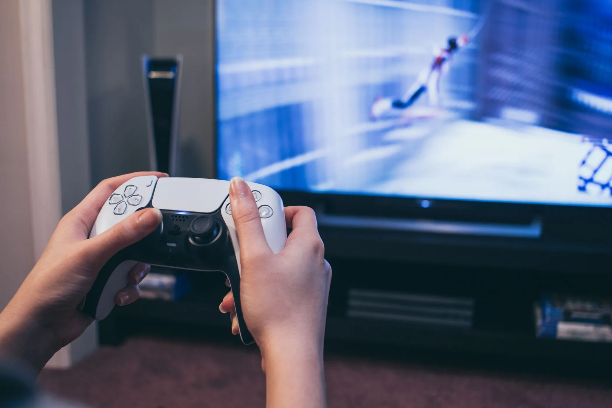 Người chơi cầm tay cầm DualSense của PS5, màn hình hiển thị game Spider-Man, gợi ý tính năng chia sẻ game trên PlayStation.