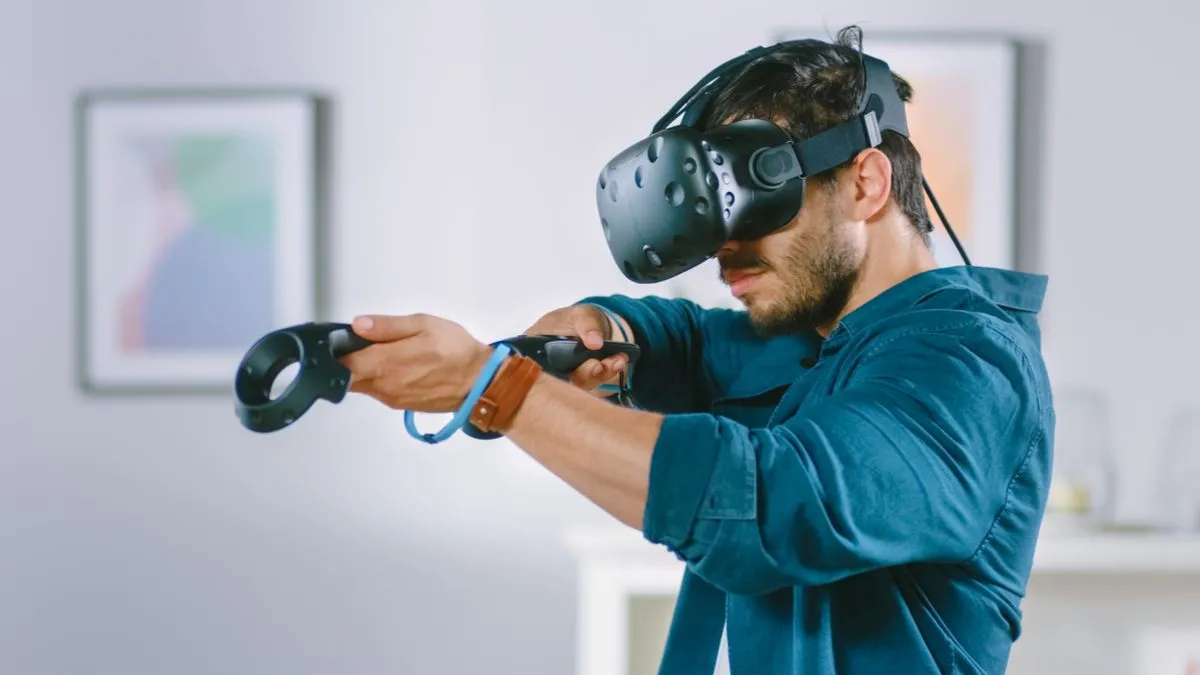 Người đàn ông trải nghiệm VR với kính thực tế ảo và bộ điều khiển, thể hiện sự phát triển của công nghệ game.