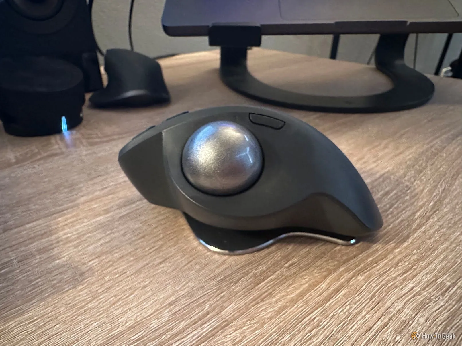 Người dùng thao tác với chuột trackball Logitech MX Ergo S trên mặt bàn, thể hiện góc nghiêng điều chỉnh.