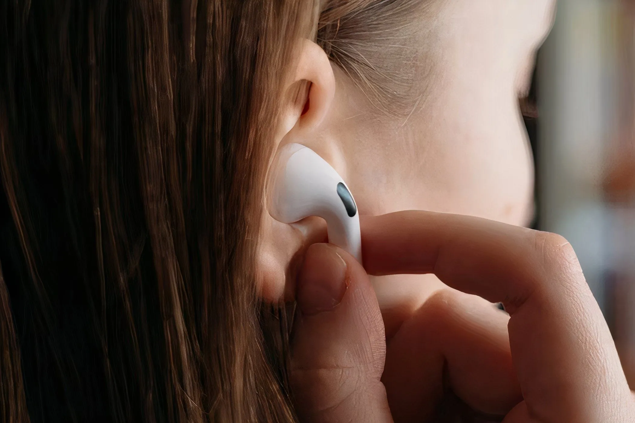 Người phụ nữ đeo tai nghe AirPods Pro vào tai.