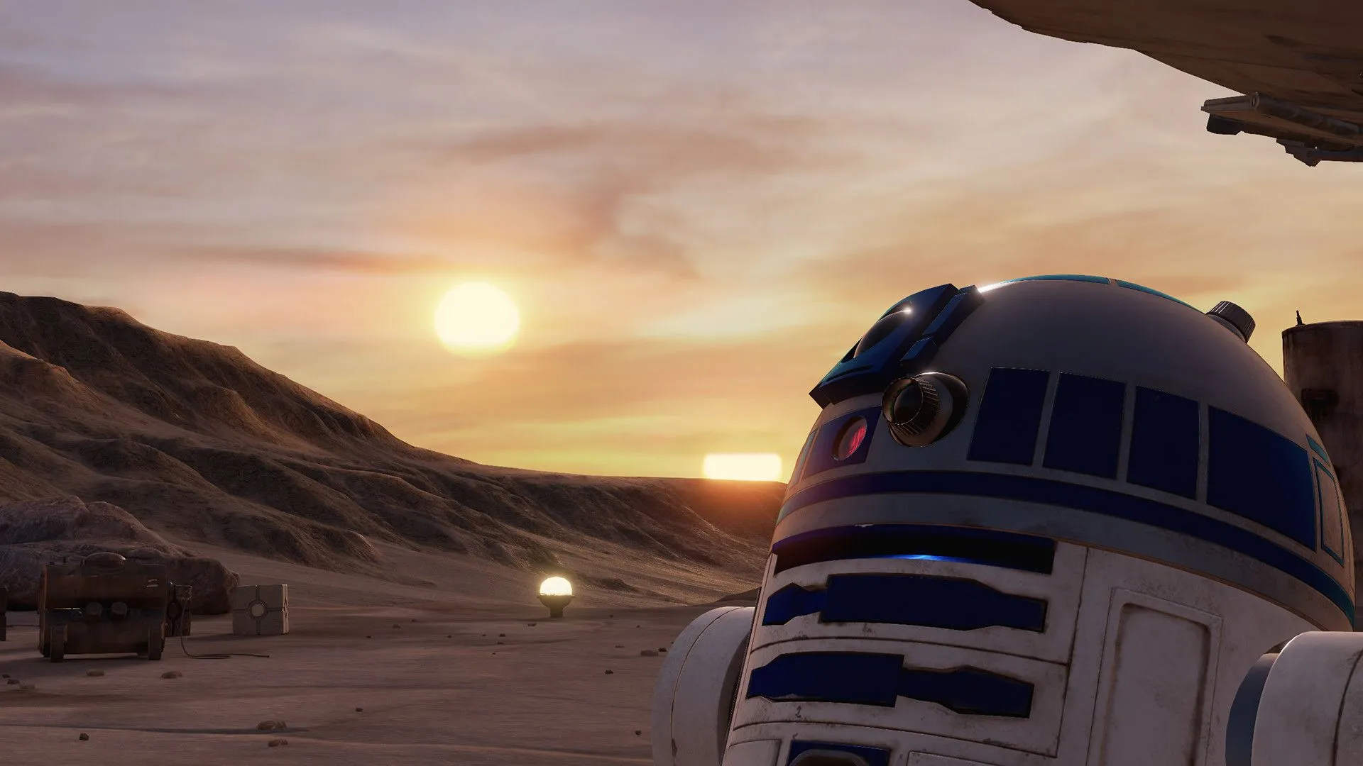 R2-D2 giữa sa mạc với phi thuyền Millennium Falcon và mặt trời lặn phía sau trên hành tinh Tatooine.