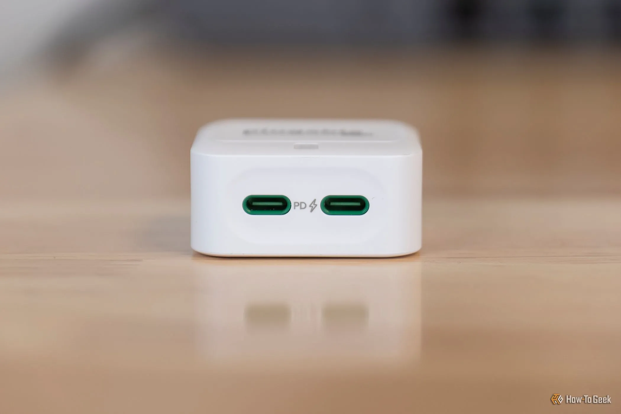 Sạc Plugable 40W USB-C kép đặt trên bàn, thể hiện thiết kế siêu nhỏ gọn và các cổng USB-C hướng xuống tiện lợi.